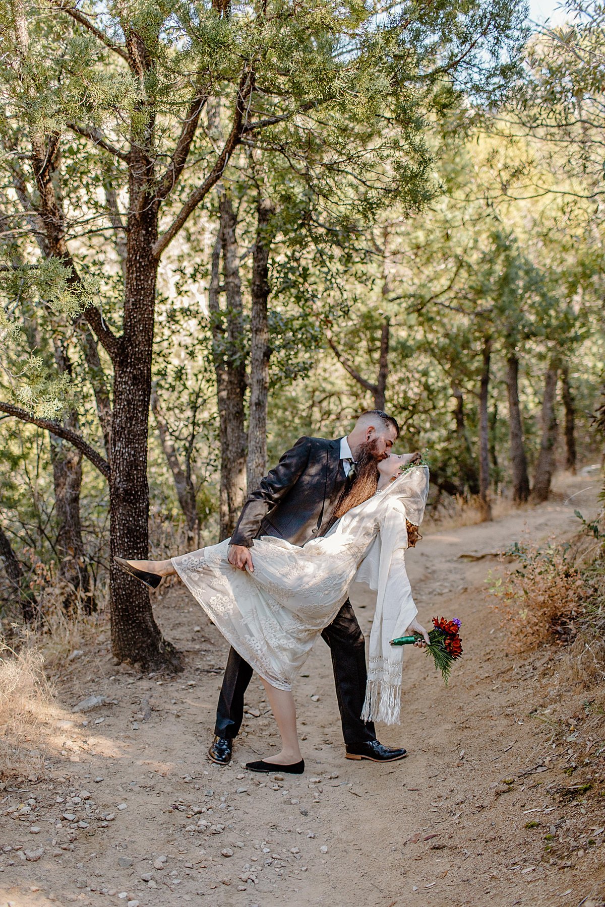  groom holding wife wearing vintage wedding dress and holding wedding bouquet  