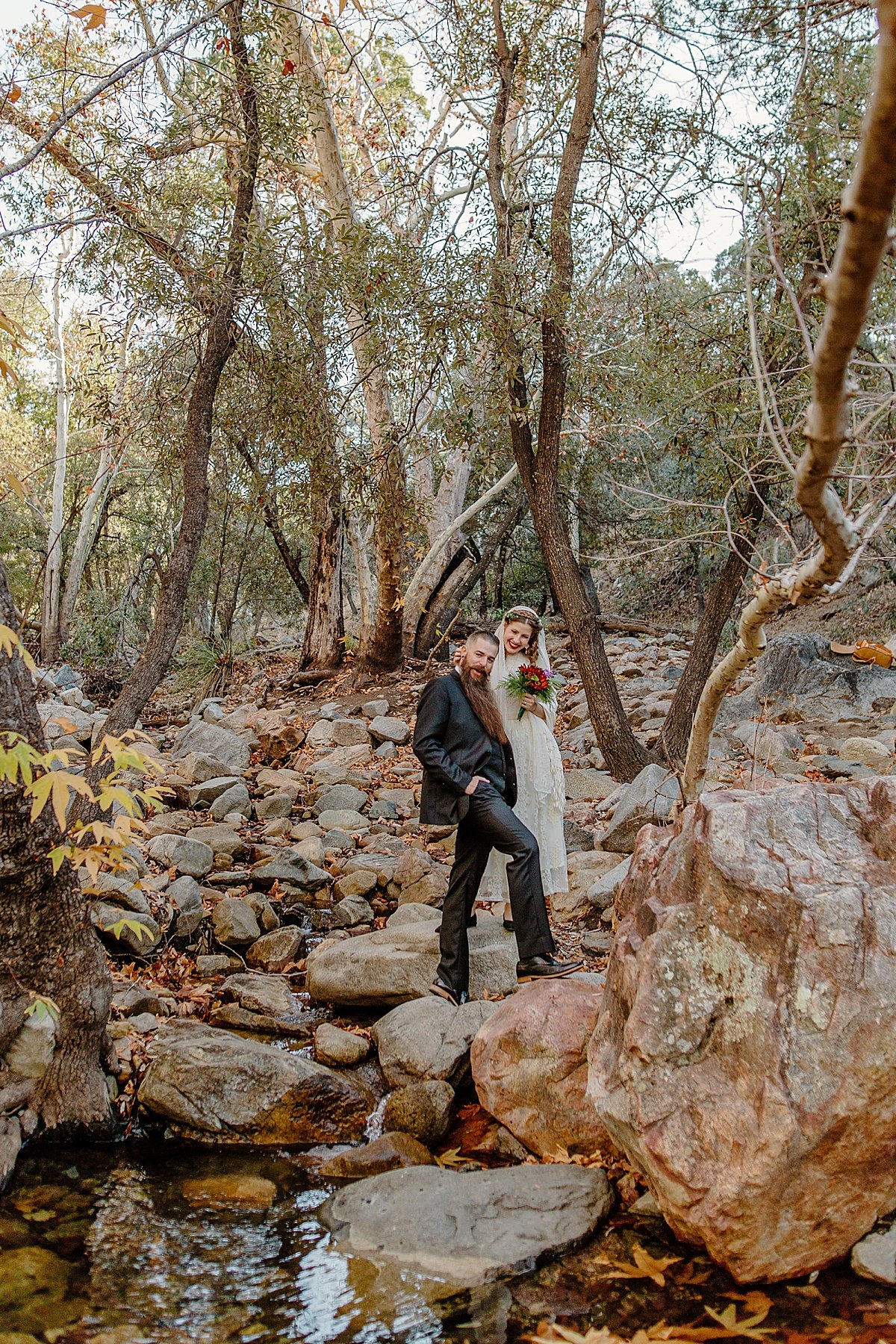  married couple walking through riverside of canyon before vow renewal in arizona  