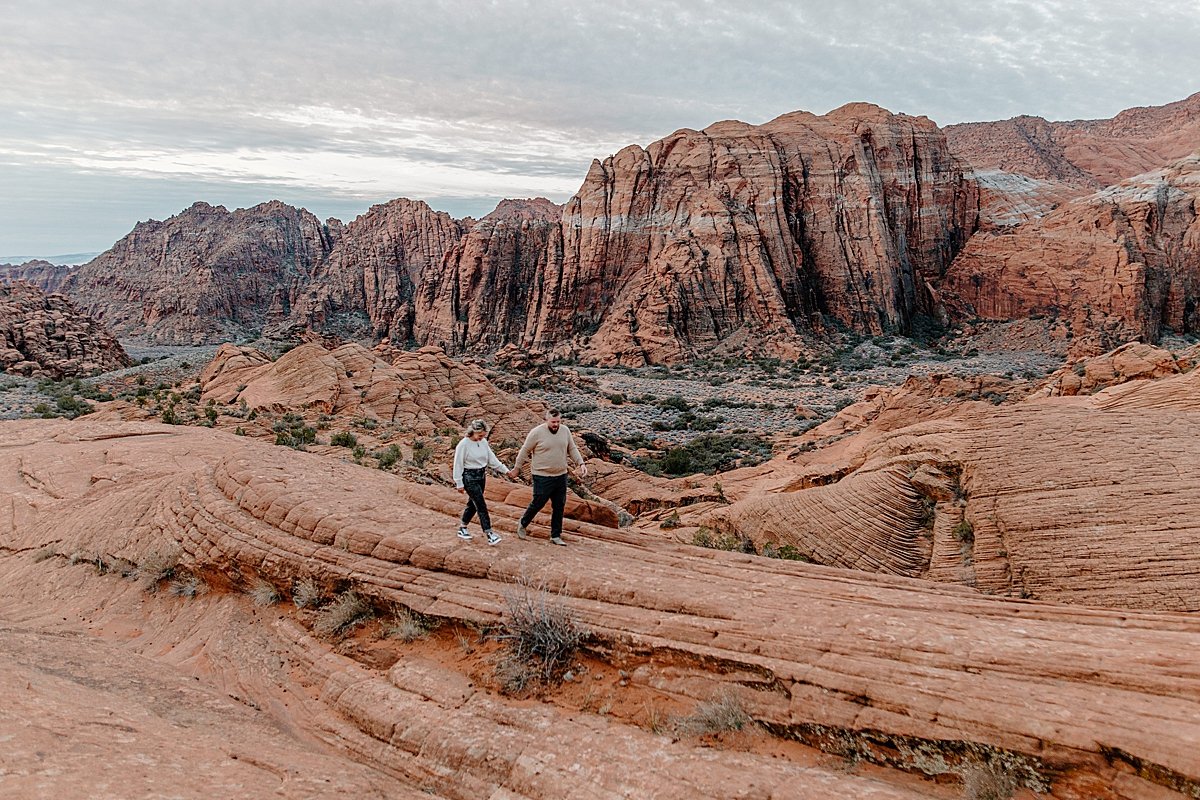  couple walking along the red rocks outside of snow canyon state park slot canyons 