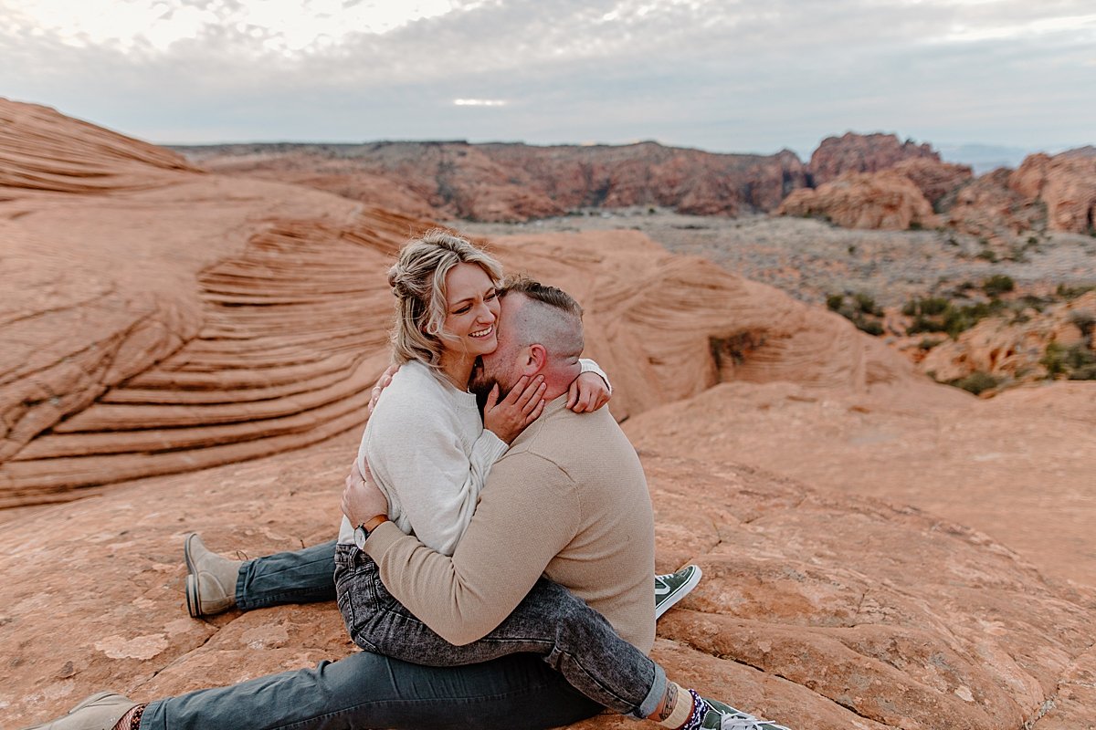  woman laughing at joking fiancé at sunrise session with Arizona couples photographer 