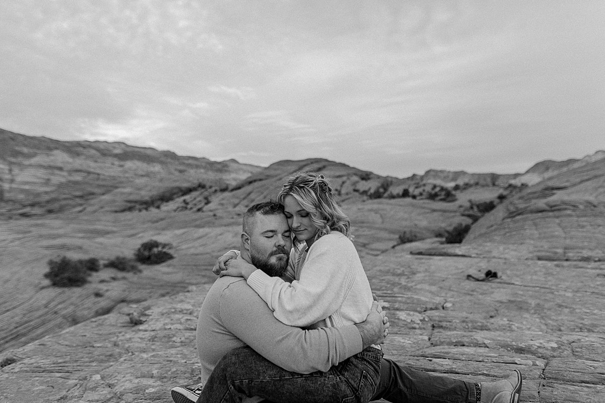  intimate moment on finances laugh sitting on Utah red rocks  