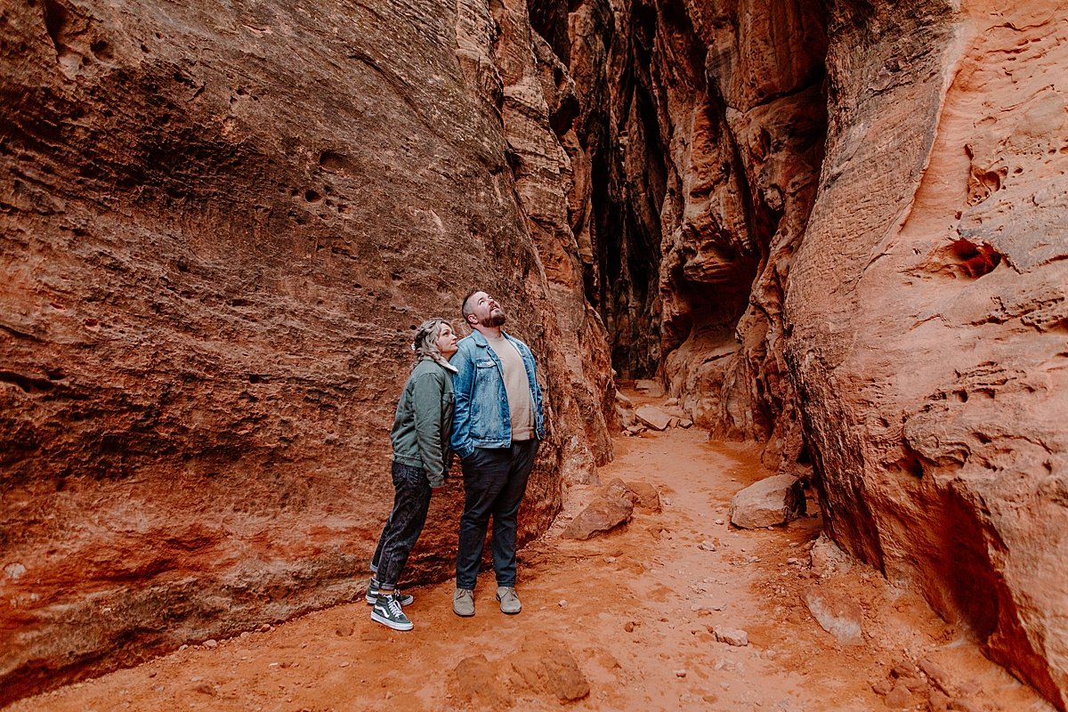  couple looking up at the sky in slot canyon in Utah for couples session 