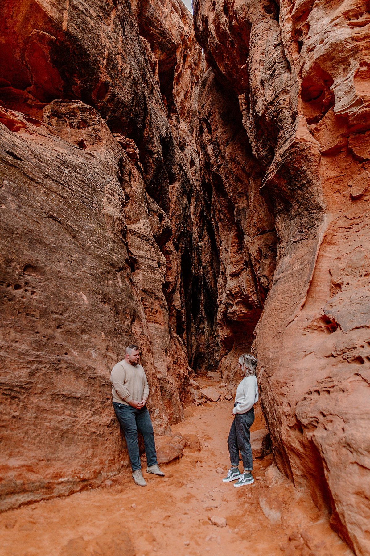  man and woman leaning up against slot canyon at Utah adventure session 