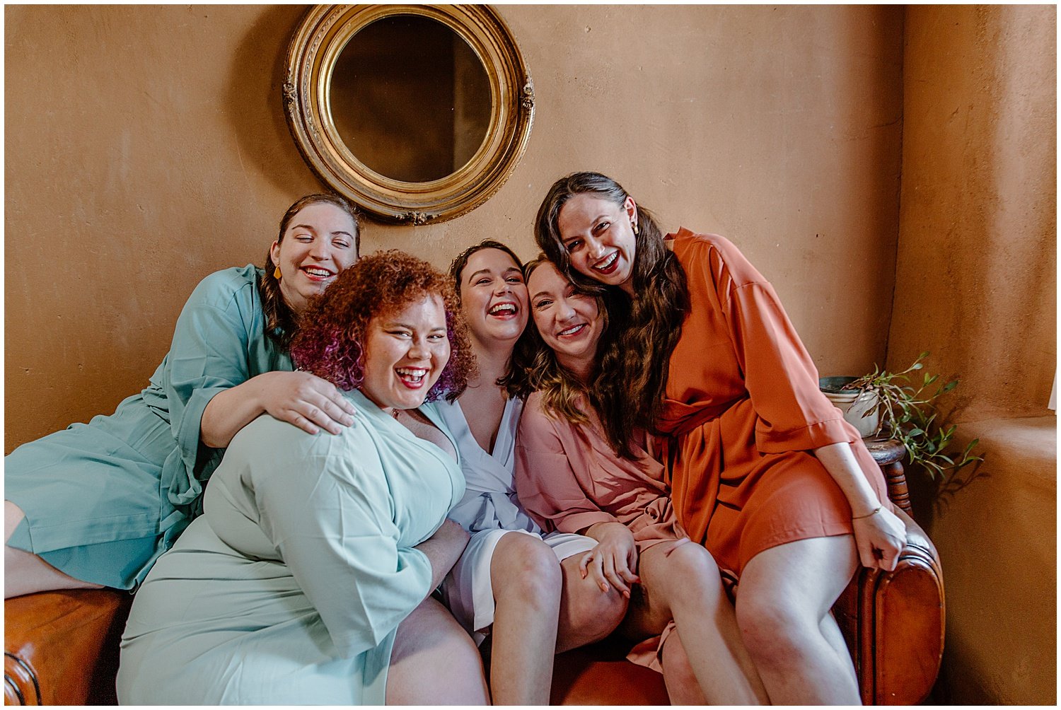  bride and bridesmaids sitting on couch in robes before ceremony for Tucson Intimate Wedding 