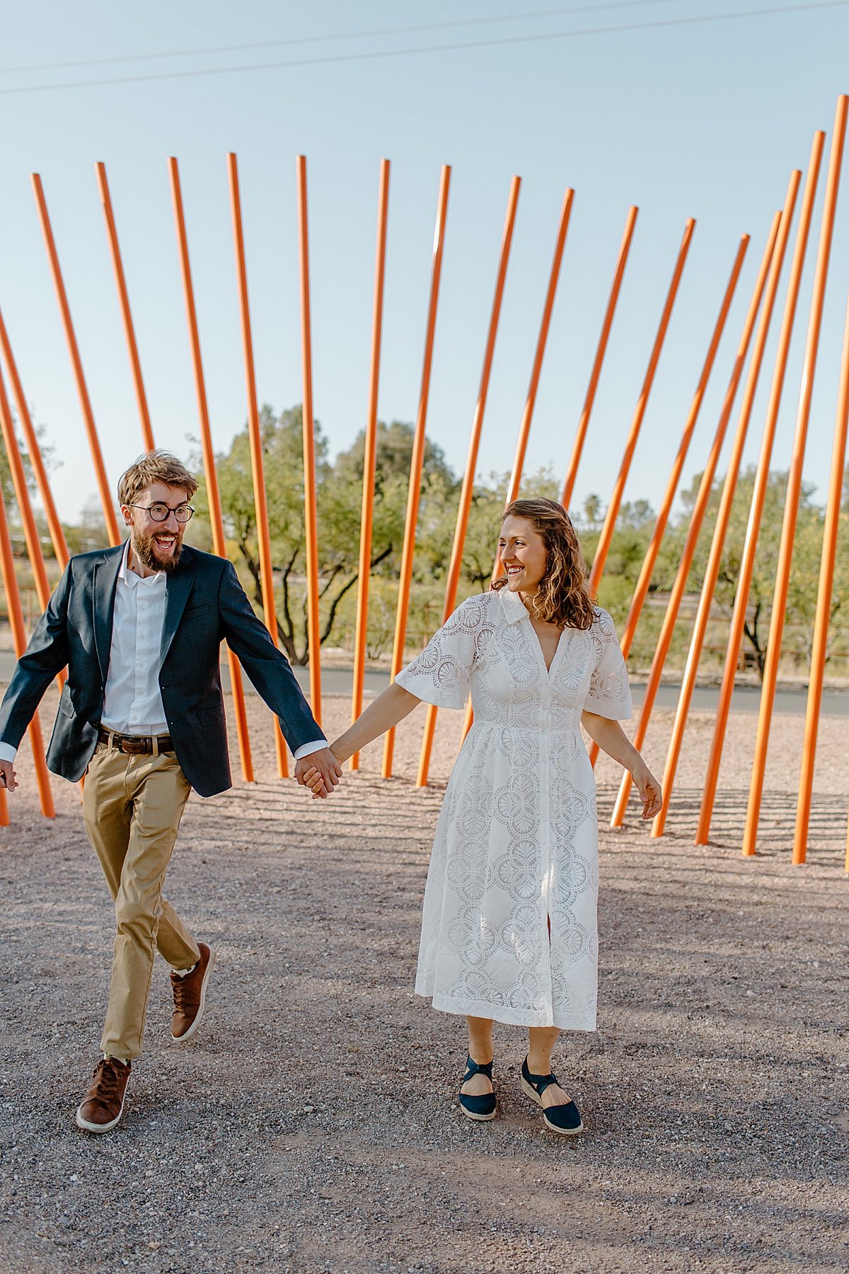  newly engaged man and wife holding hands through the streets by Arizona couples photographer 