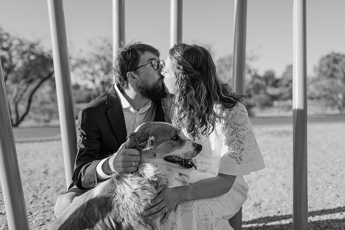  couple kisses while dog looks at the camera by Arizona couples photographer 