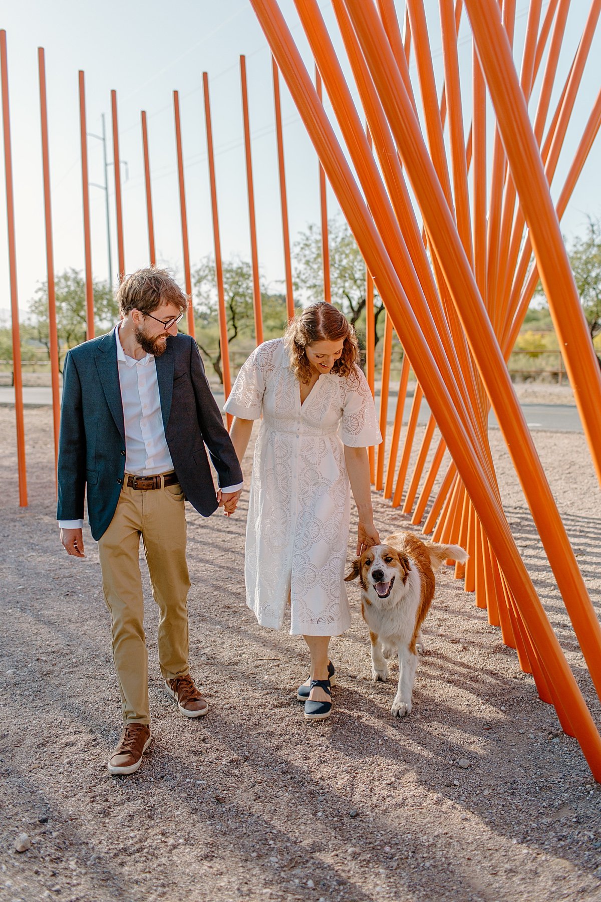  couple walking dog wearing dress and suit coat in downtown Tucson engagement session  