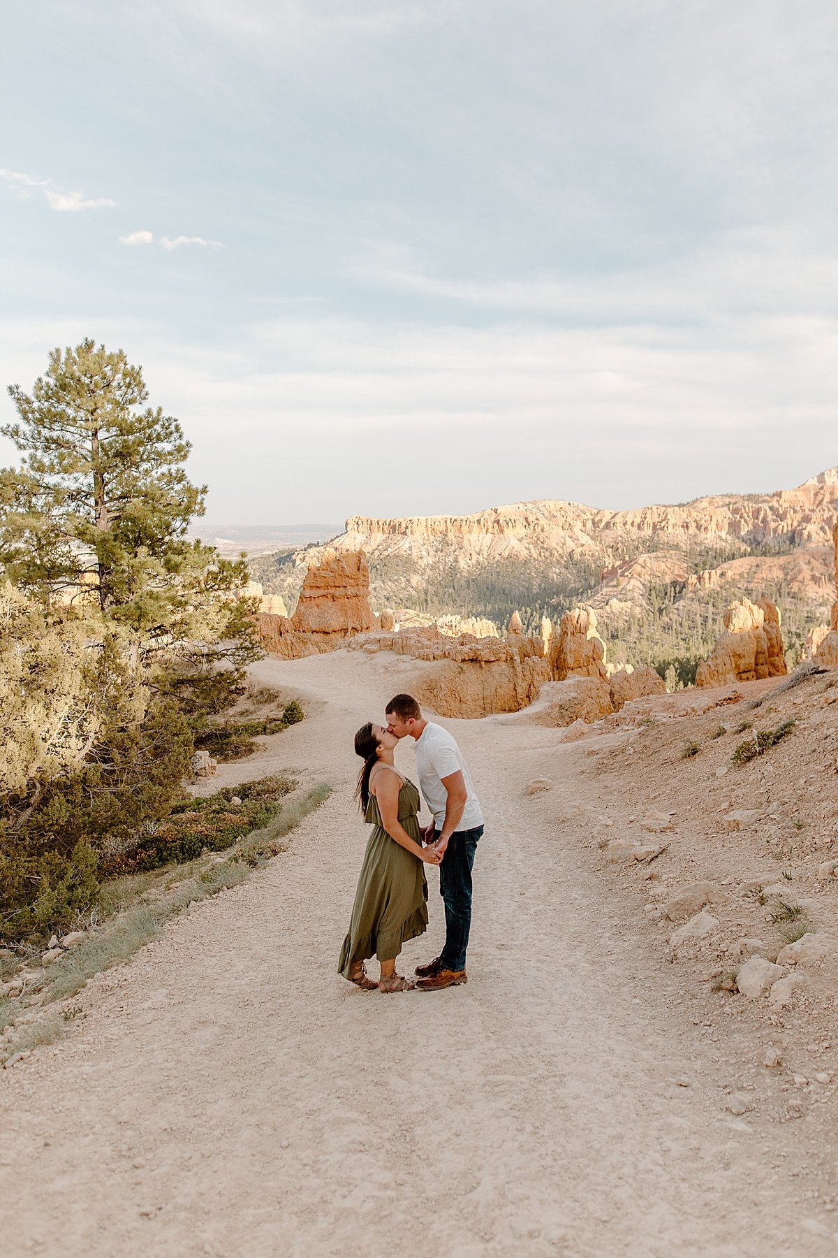  Bryce canyon adventure session with couple in roadway wearing green dress and Brown sandals 