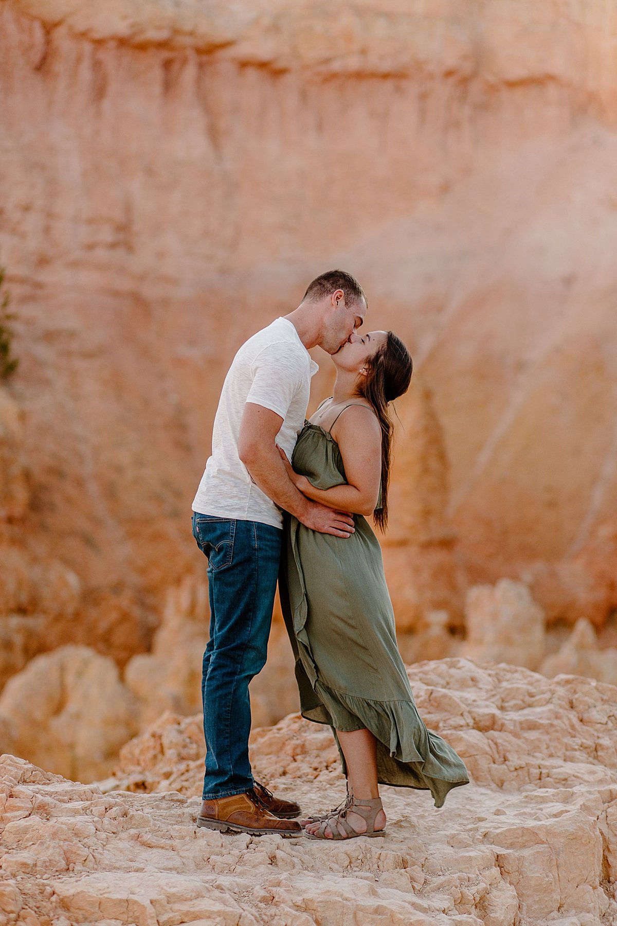  Man and Woman kissing in dress clothes at Bryce Canyon by Utah couples photographer 