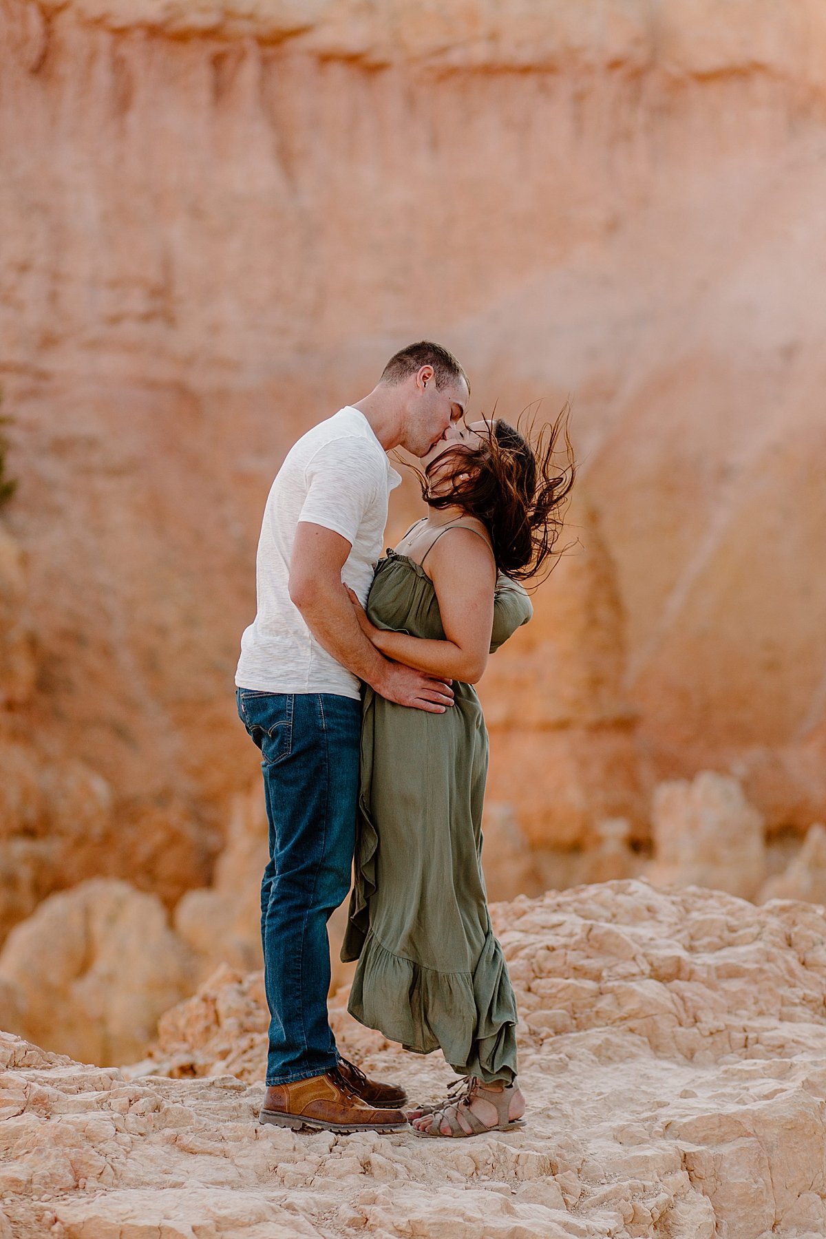  Wind flying up woman's hair while kissing fiancé by Lucy Bouman 