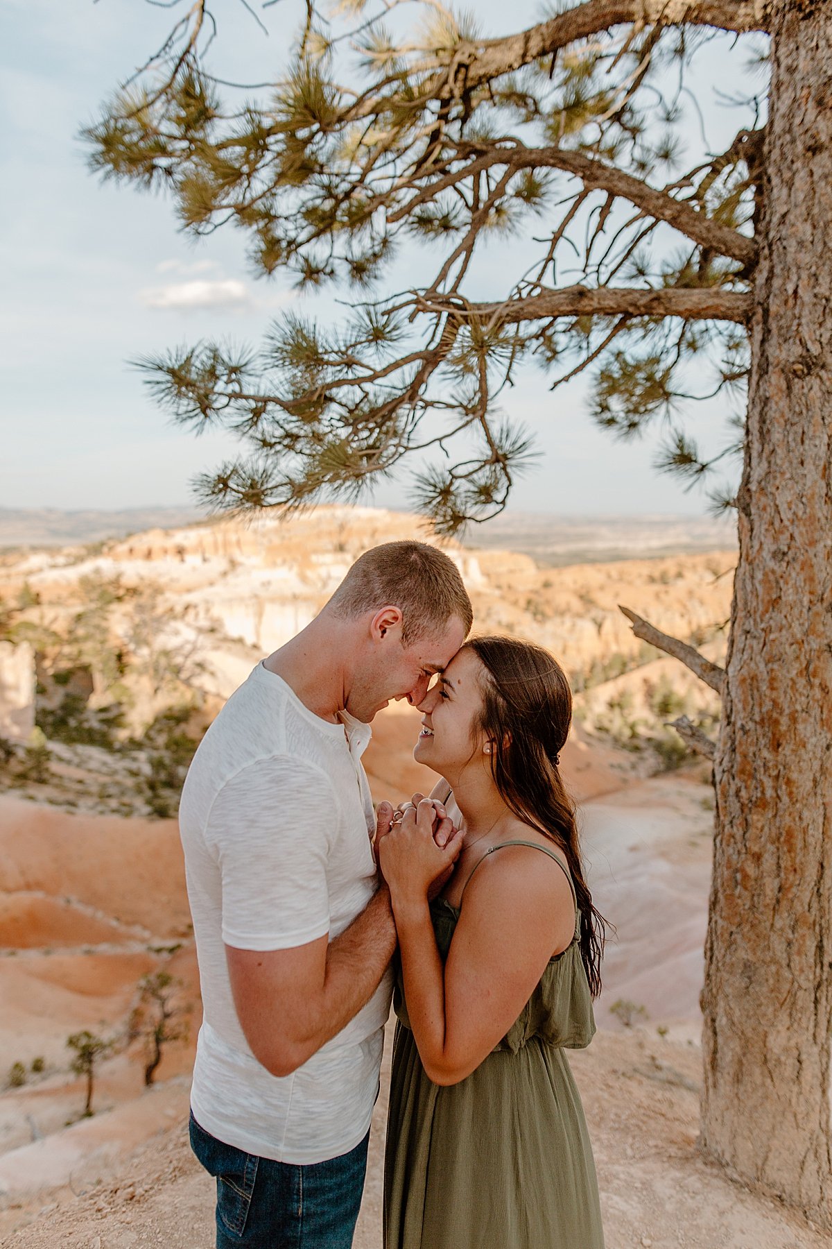  Man and woman for head for head holding hands underneath Utah tree in state park by Lucy Bouman 