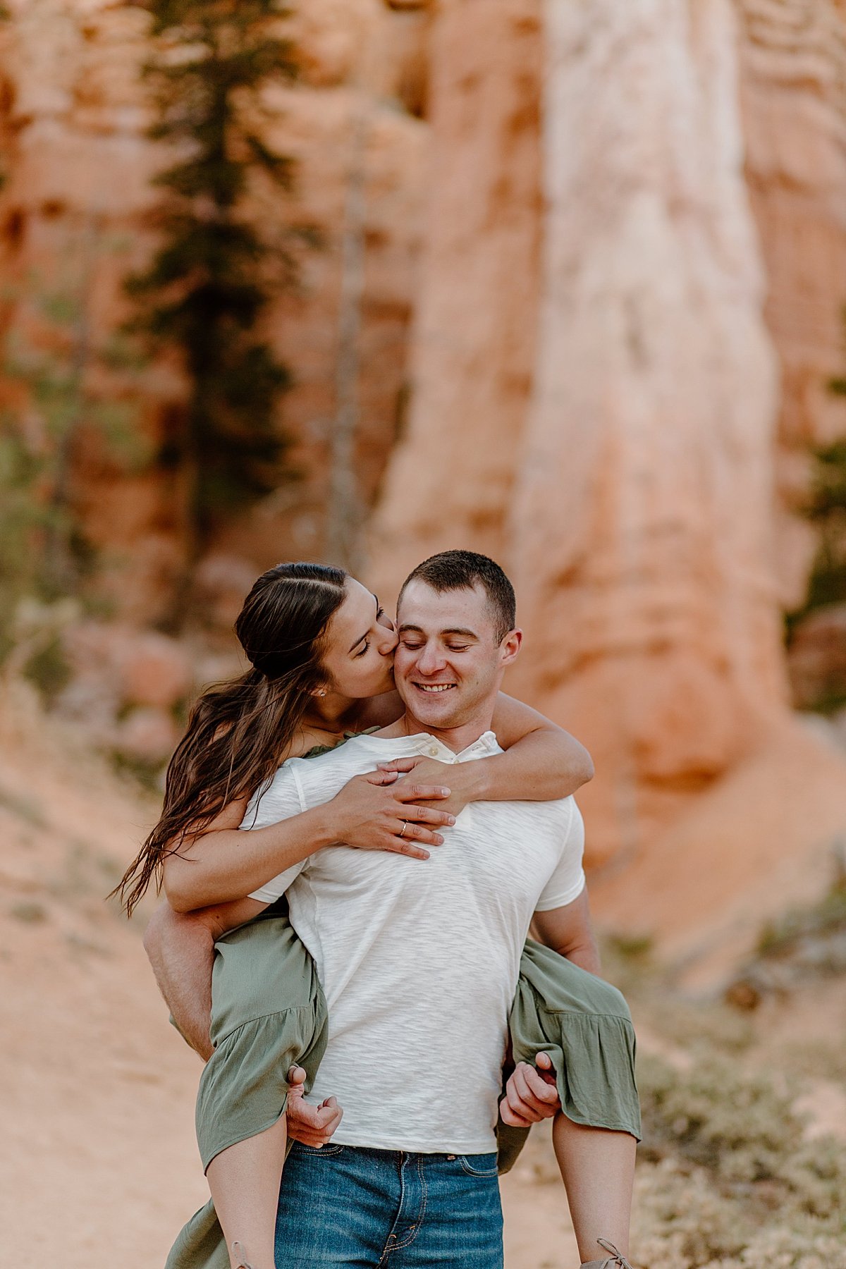  Man gives fiancé piggy back ride through Bryce Canyon by Utah couples photographer 