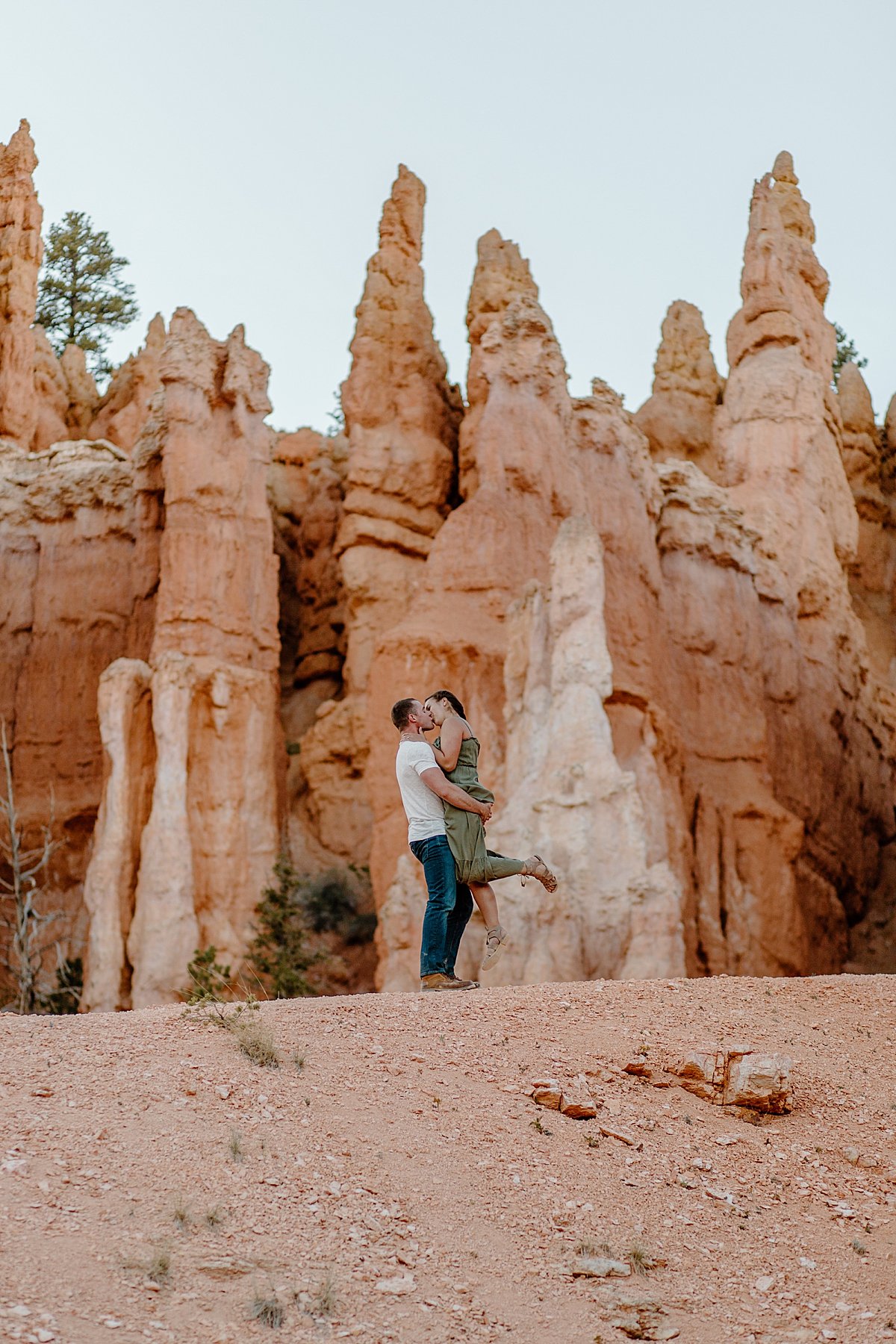  Woman getting held up and popping leg during engagement session with Utah couples photographer 