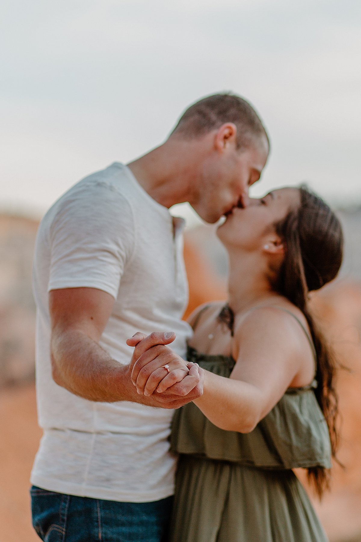  Women showing off diamond engagement ring with green dress and white T-shirt 