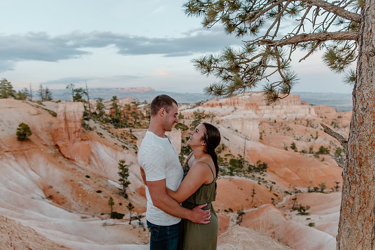  Engaged man and wife standing in front of Canyon in Utah for Bryce canyon adventure session 