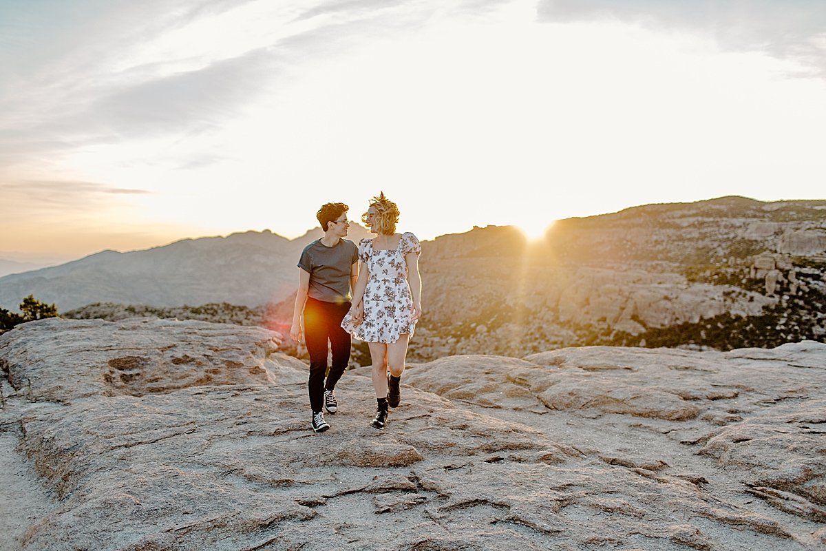  Wide portrait of couple walking on rocks is sun is going down at Windy point by Lucy Bouman photography 