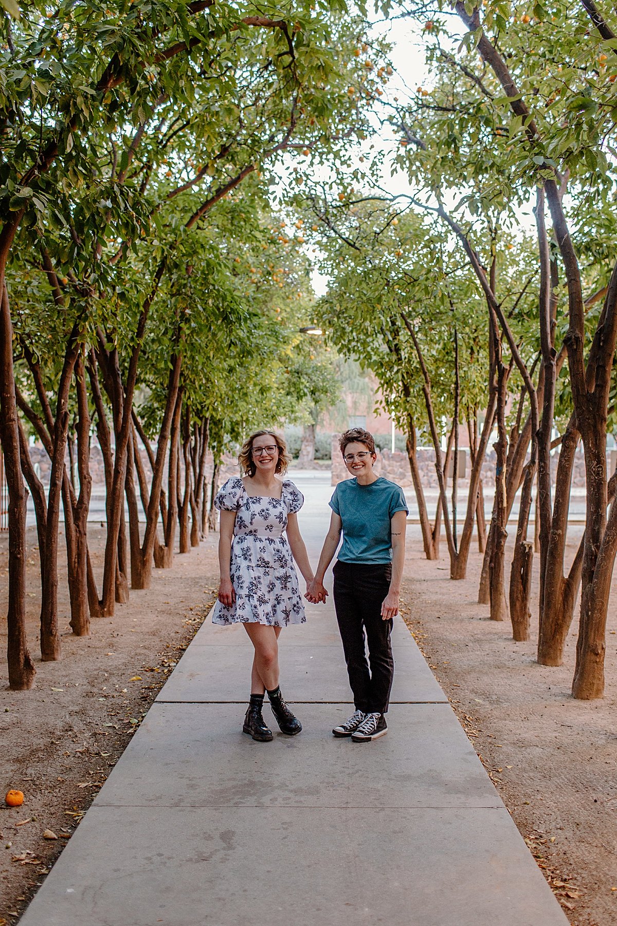  Hand in hand walking campus path in Arizona by Tucson engagement photographer 