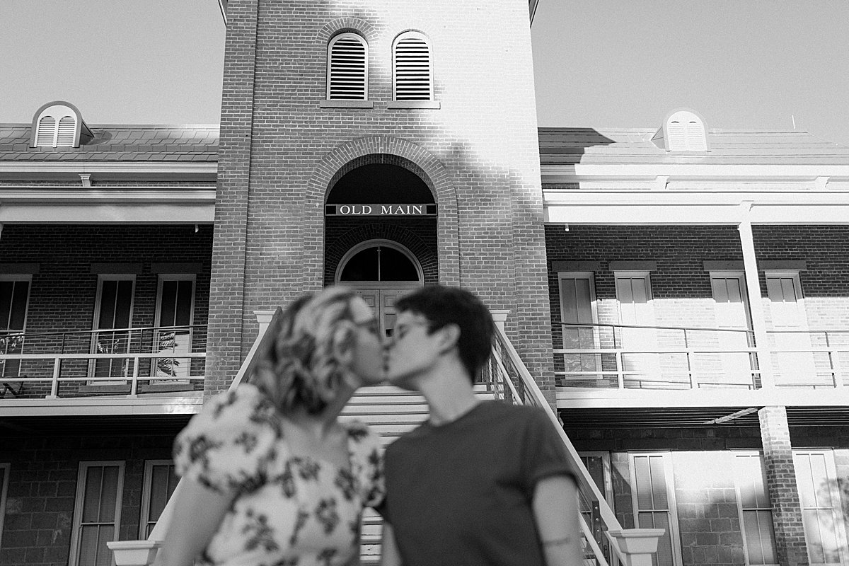  Kissing in front of campus building in black and white portrait buy Tucson engagement photographer 