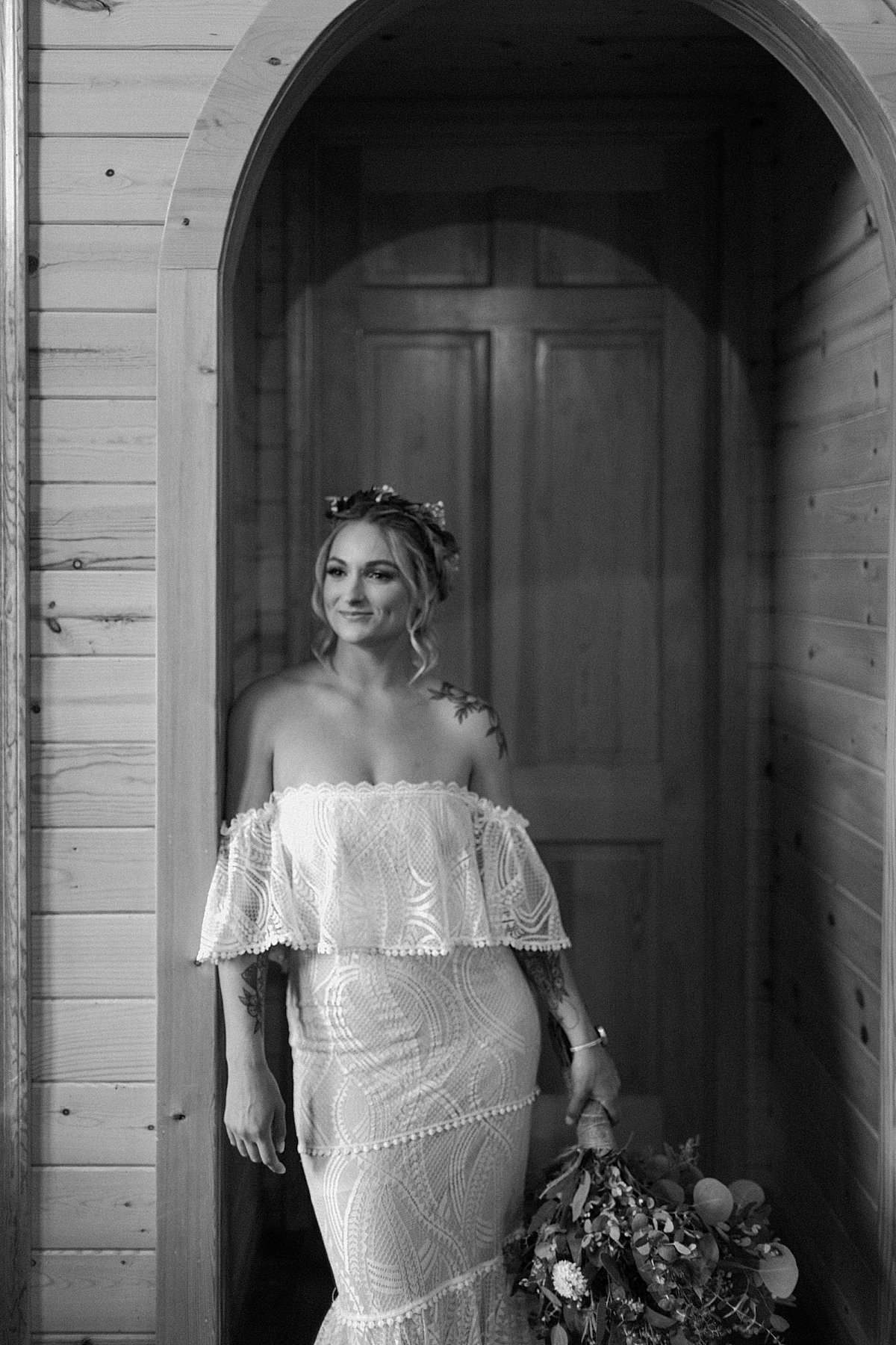  Portrait of Bride in doorway with off the shoulder wedding dress and floral headpiece by Lucy Bouman 
