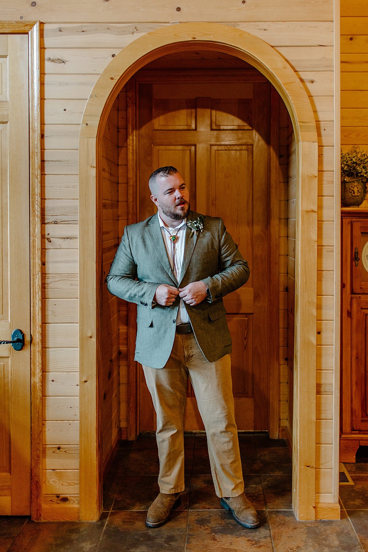  Portrait of groom standing in doorway wearing suit jacket by Arizona adventure elopement photographer 