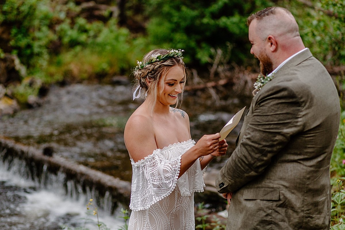  Bride reading vows to groom during intimate elopement in the woods  by Lucy Bouman 