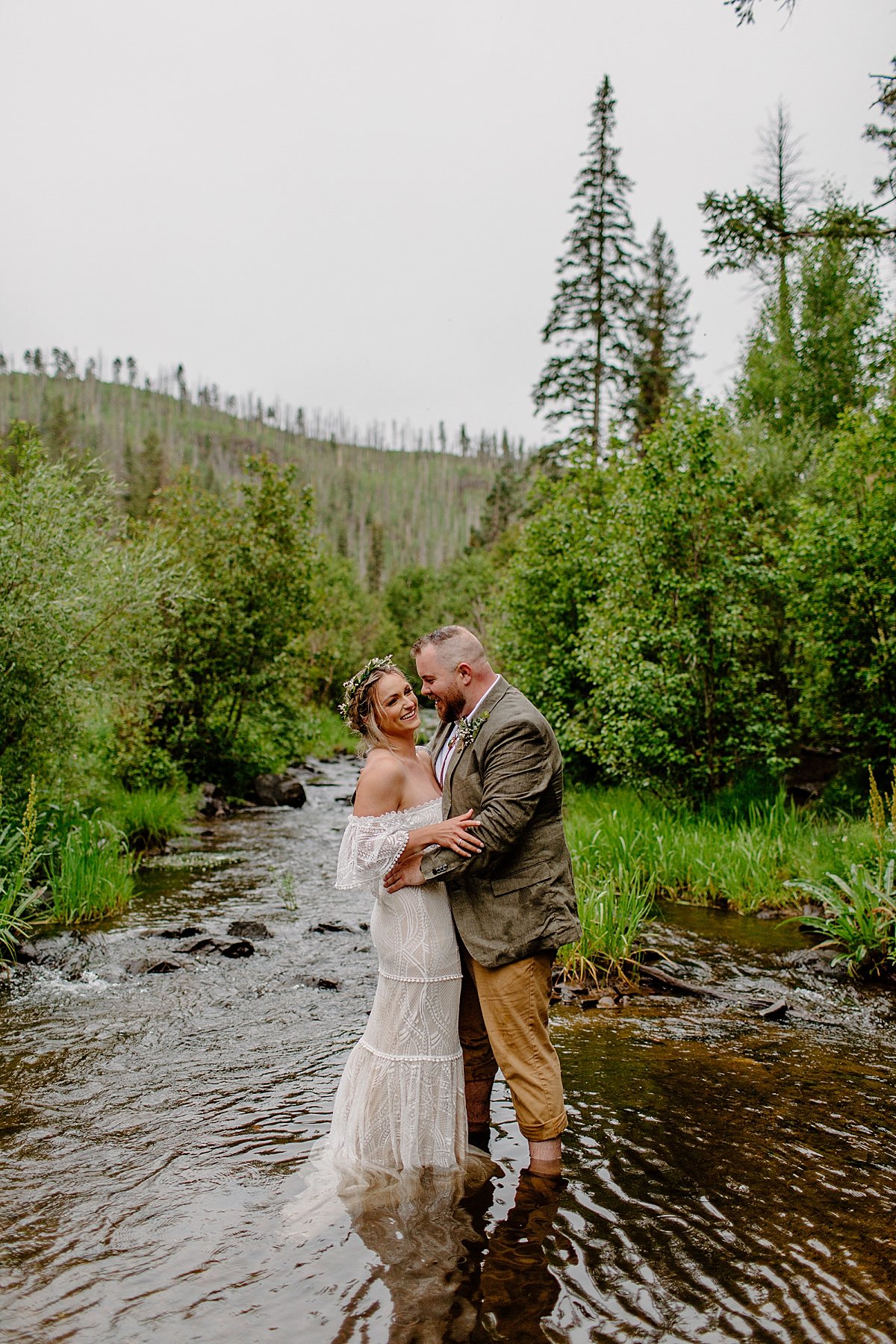  Married couple dancing in the river and wedding attire  by Lucy Bouman 