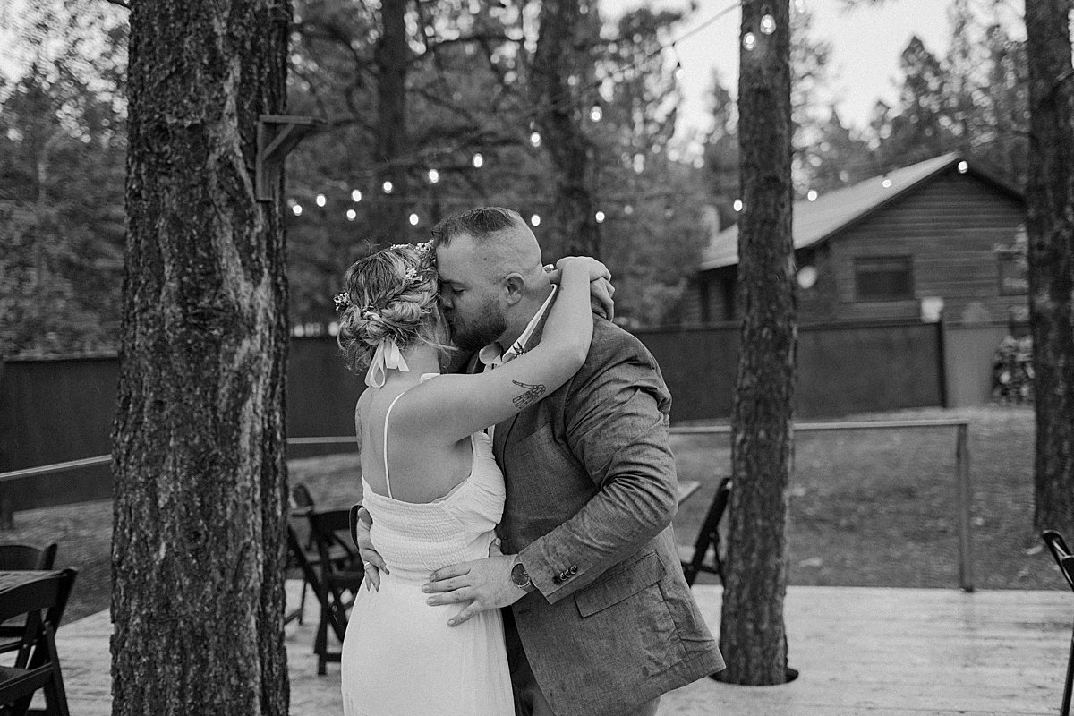  Black and white first dance photo of newly married couple under string lights at Arizona resort  by Lucy Bouman 