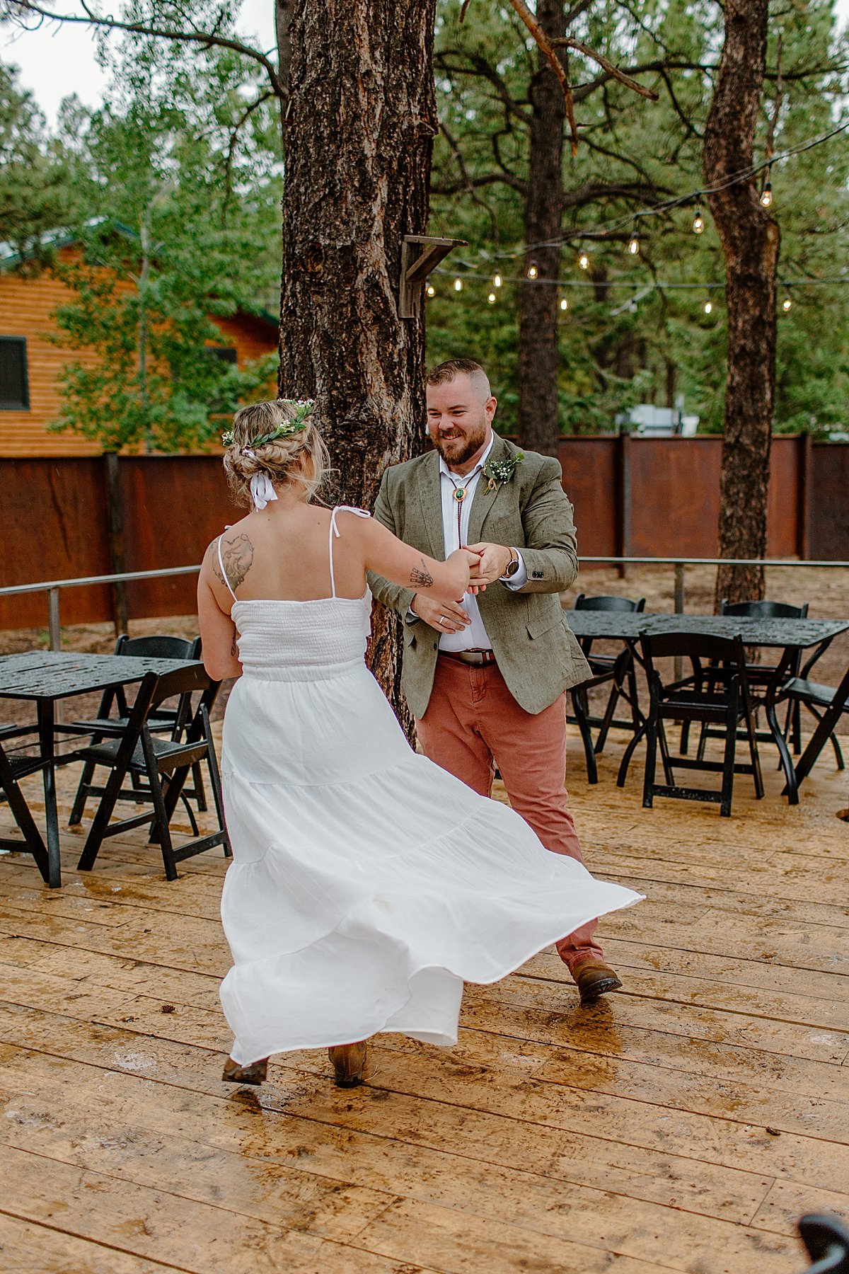  Groom twirls Bride on wood dance floor after elopement day by Arizona adventure elopement photographer 