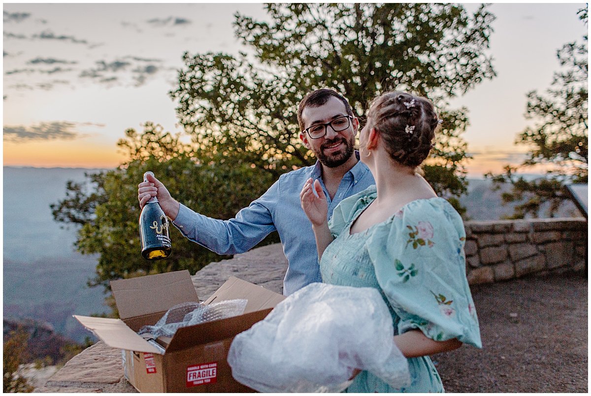  Man and woman open personalized champagne package for Lucy Bouman Photo  