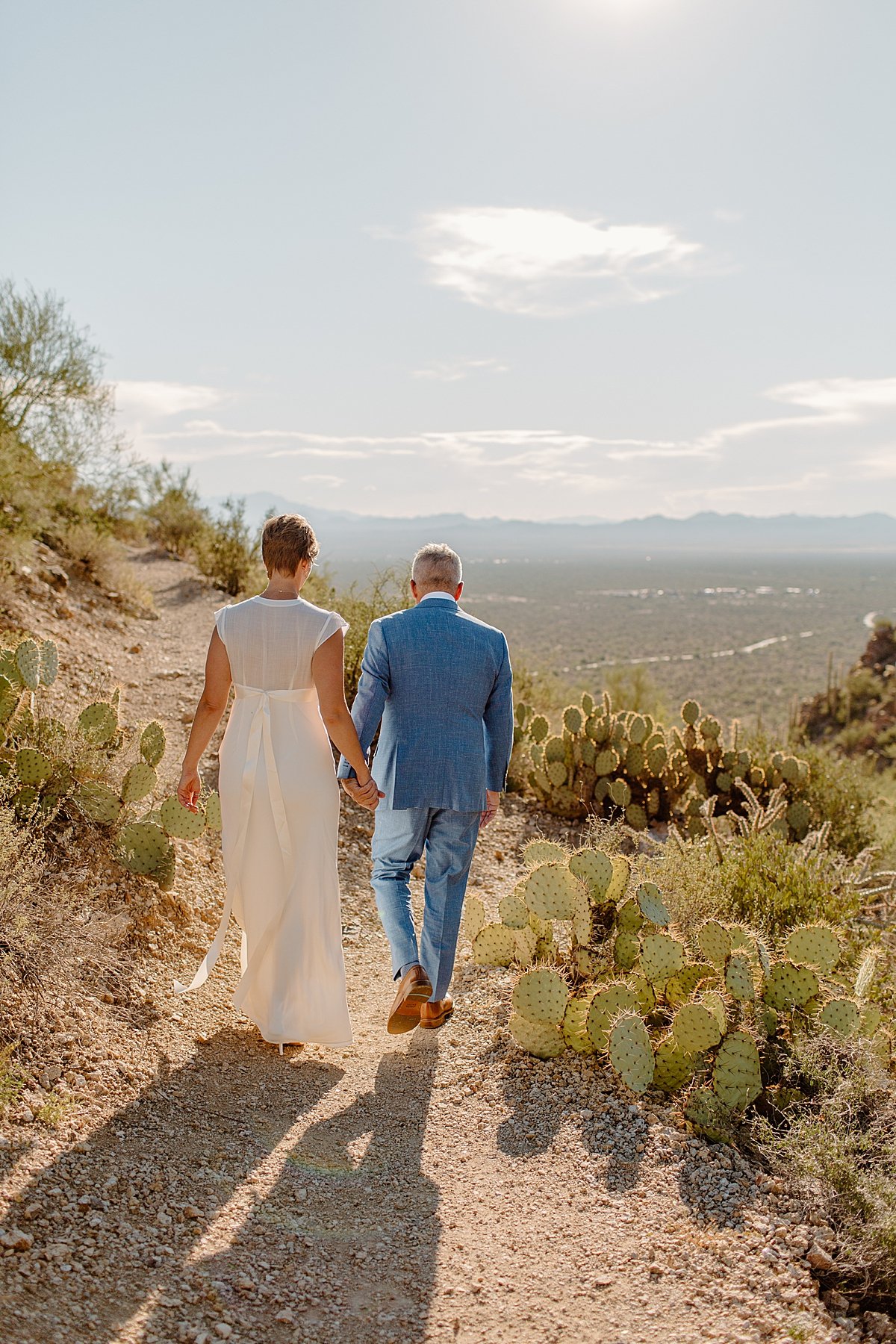  Couple walks in Saguaro National Park together 