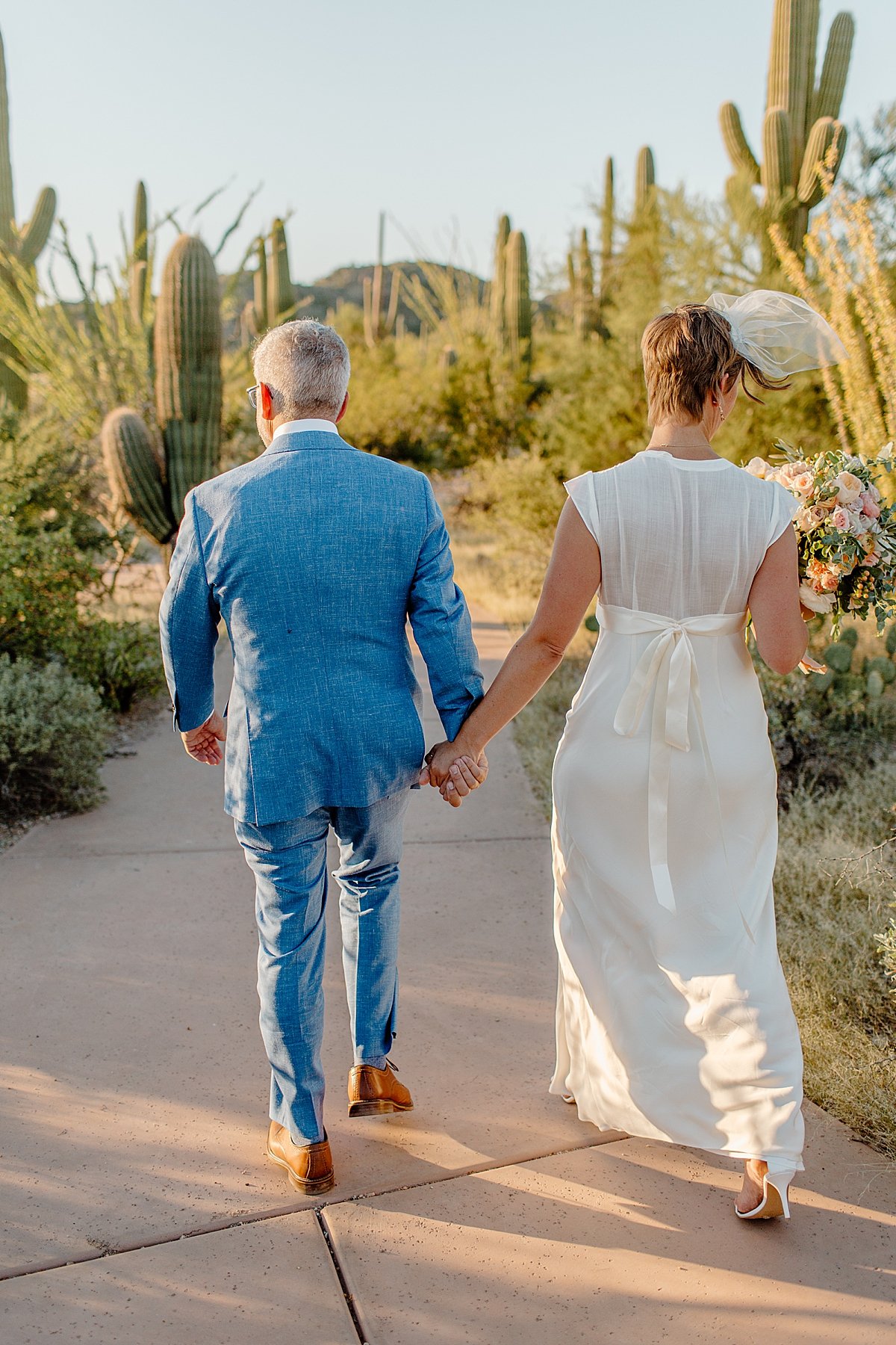  Man in blue suit and woman in white gown at Saguaro National Park 