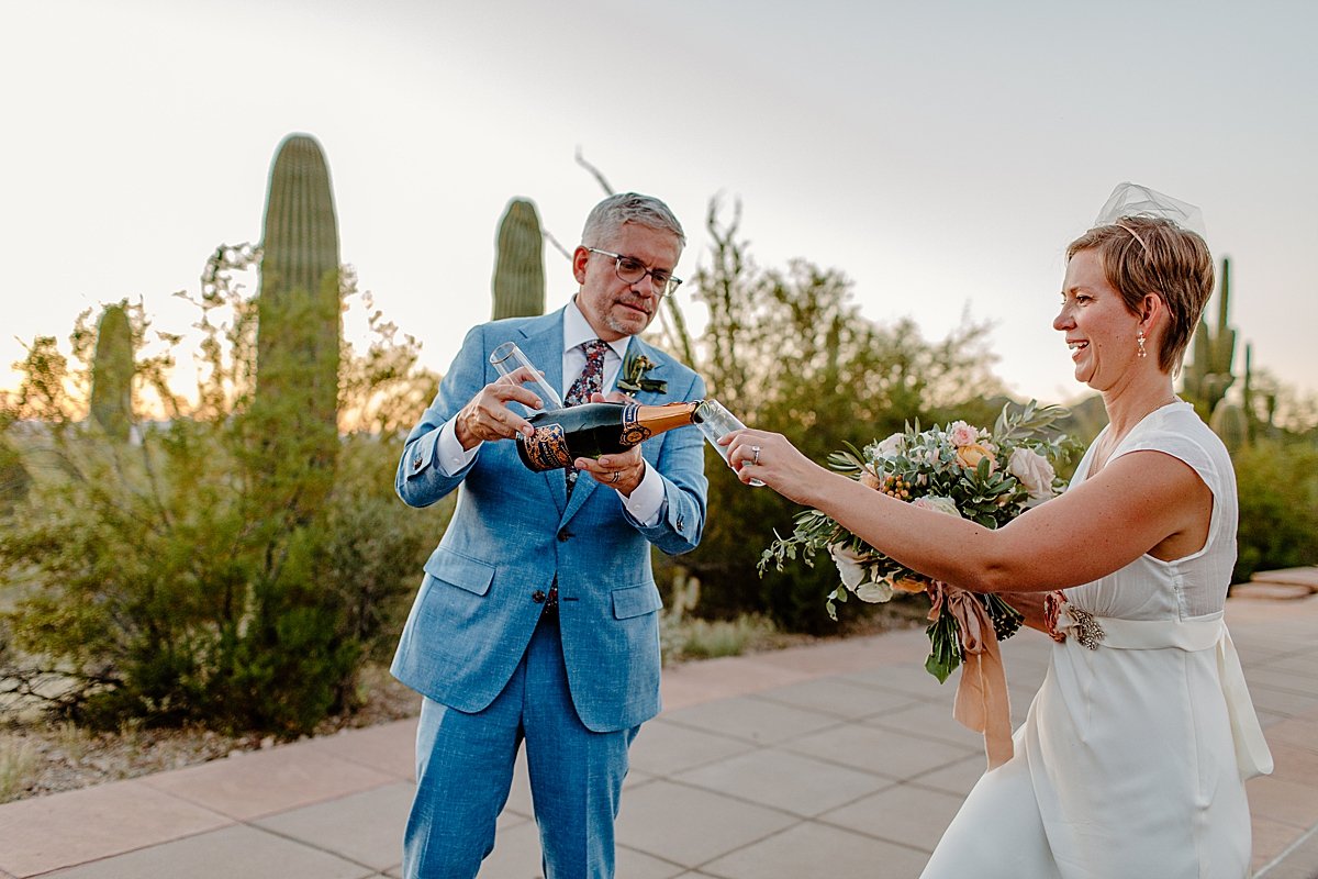  Middle aged bride and groom popping champagne by Tucson Elopement photographer 