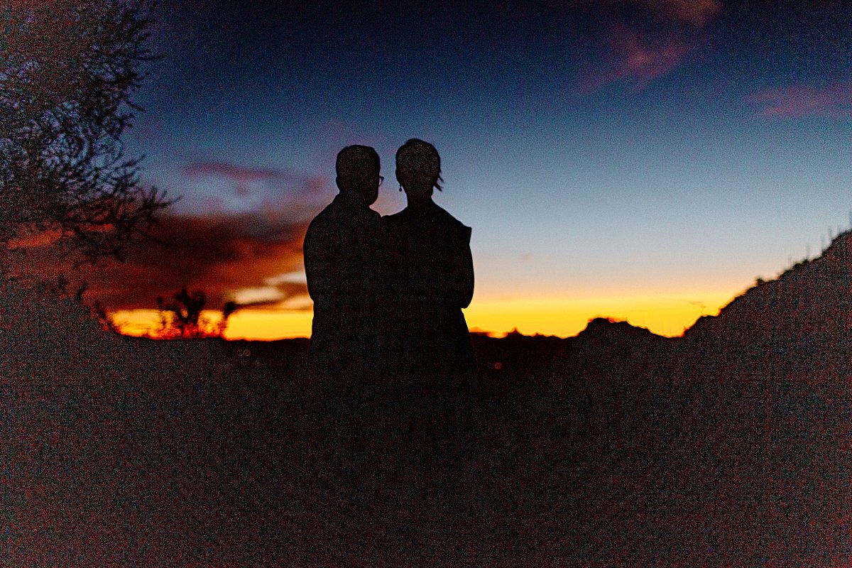  Bride and groom silhouetted against sunset  by Lucy Bouman Photography 