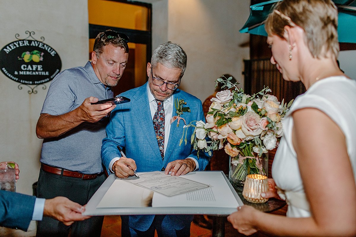  Groom signing marriage certificate  by Lucy Bouman Photography 