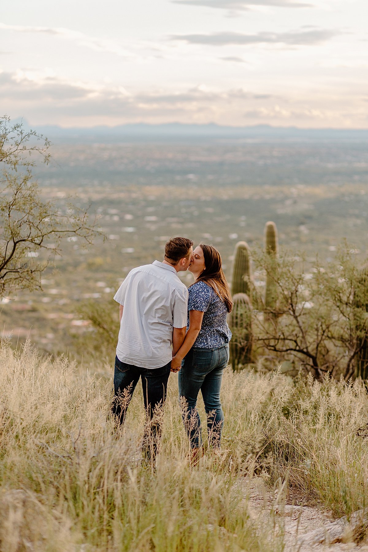  couple holds hands and kisses at  Mount Lemmon session 