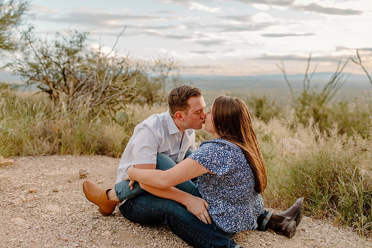  fiances sit together and kiss for Arizona engagement photographer 