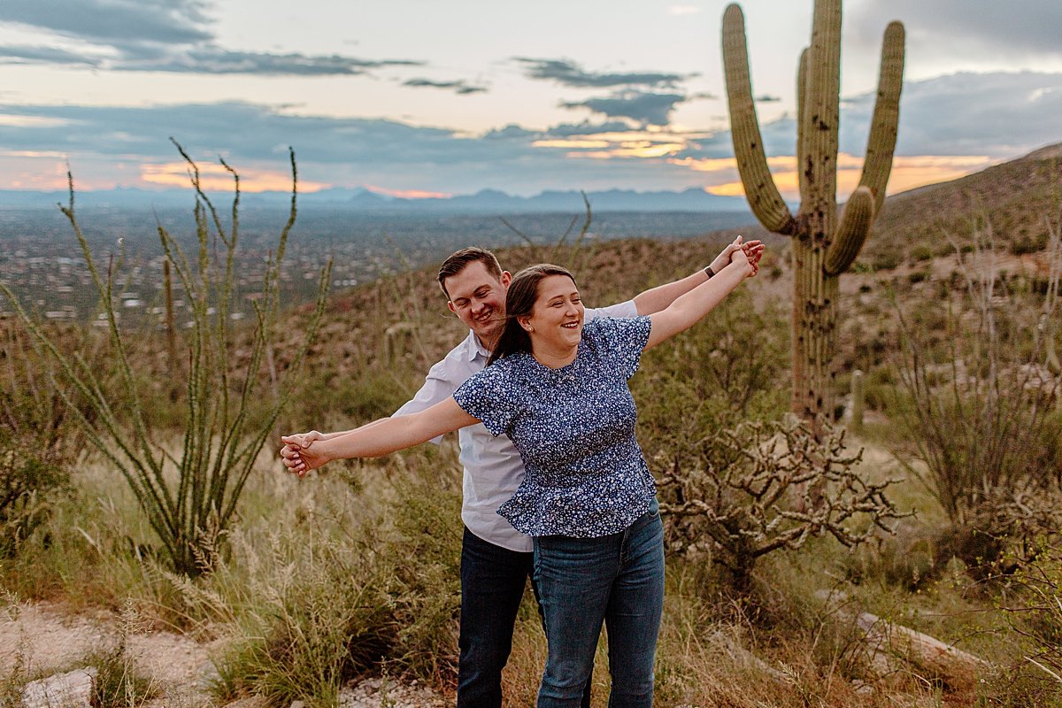  fiances hold arms out wide together for Arizona engagement photographer 