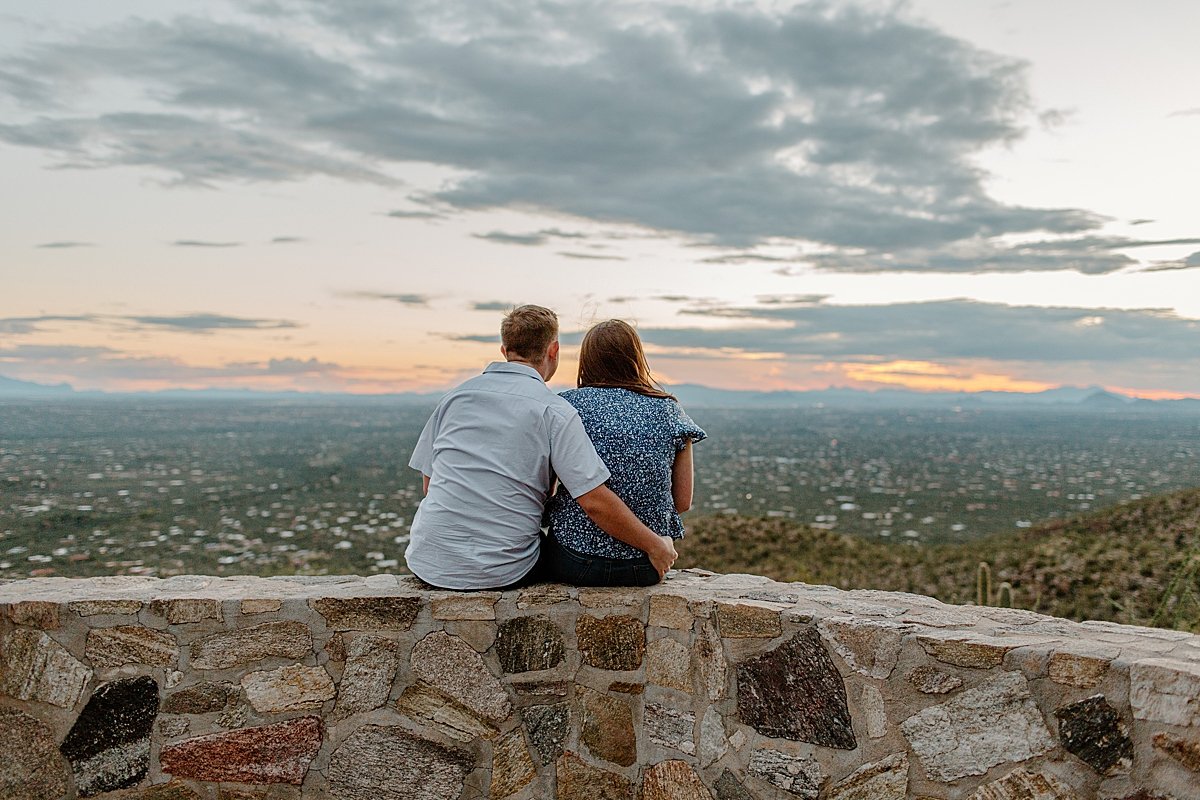  couple sits on rock wall together at  Mount Lemmon session 