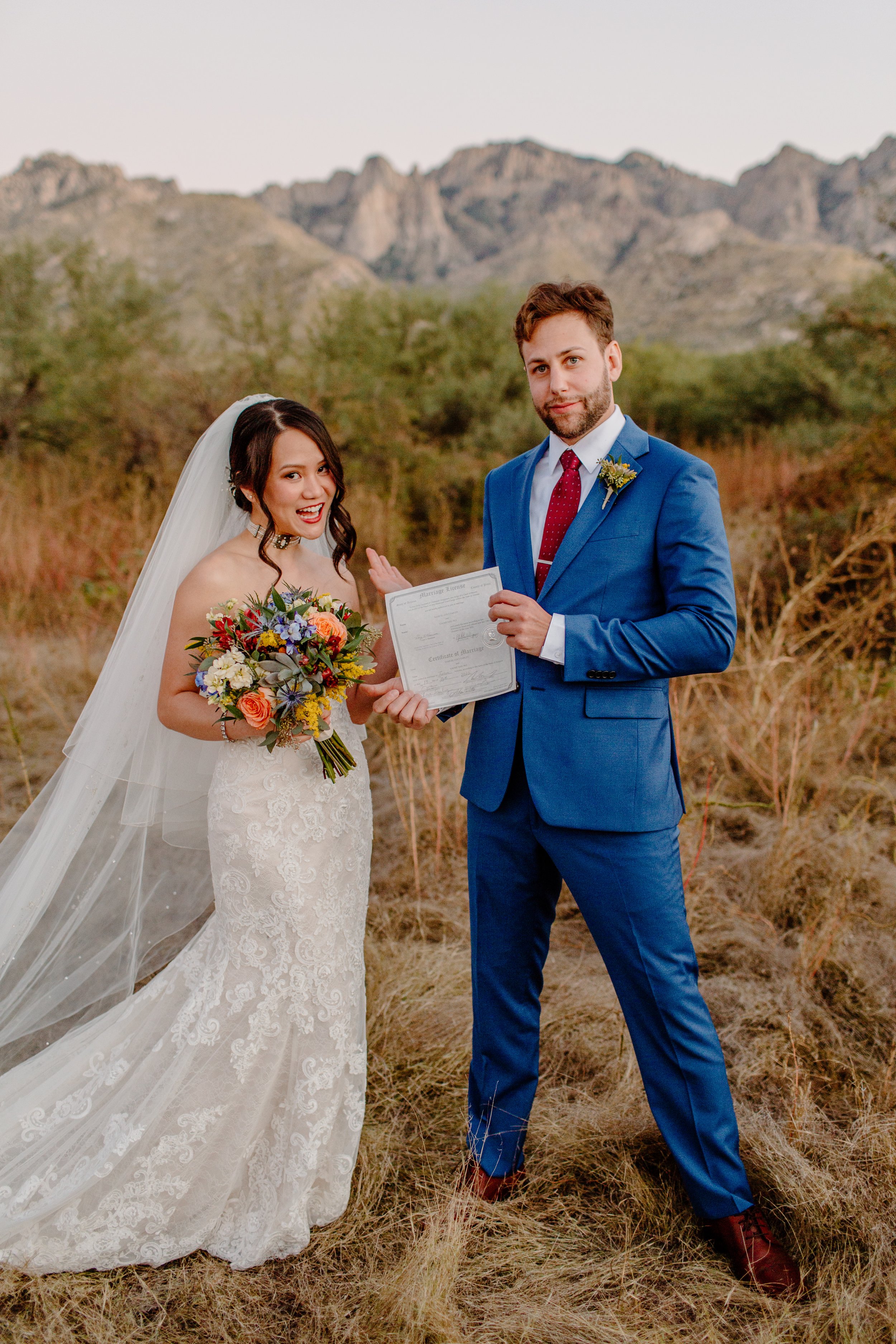  newly married couple show off marriage license after intimate desert ceremony for rock climbing session 
