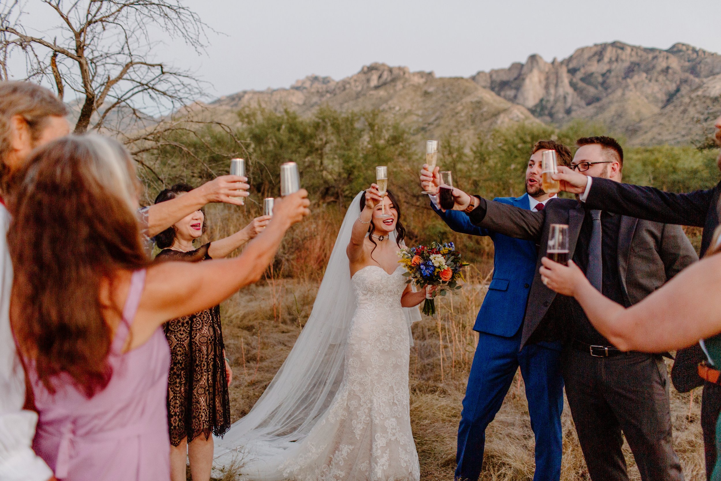  couple and guests toast champagne after ceremony by Arizona elopement photographer  