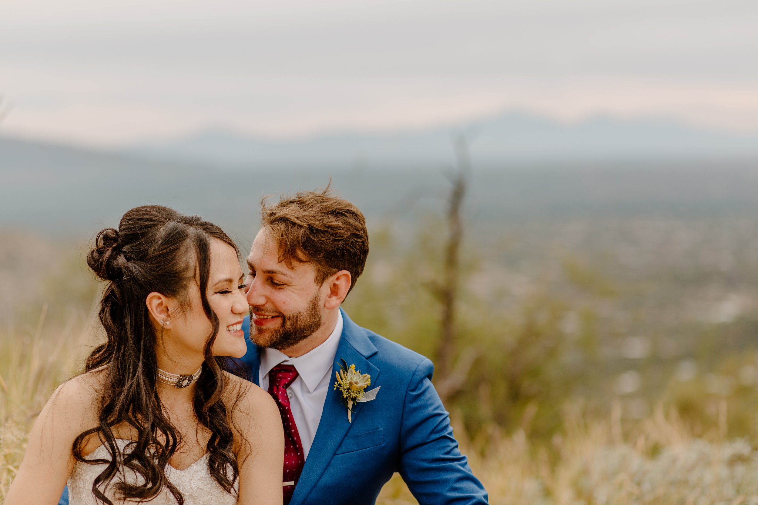  husband kisses bride sitting on the rocks by Arizona elopement photographer  