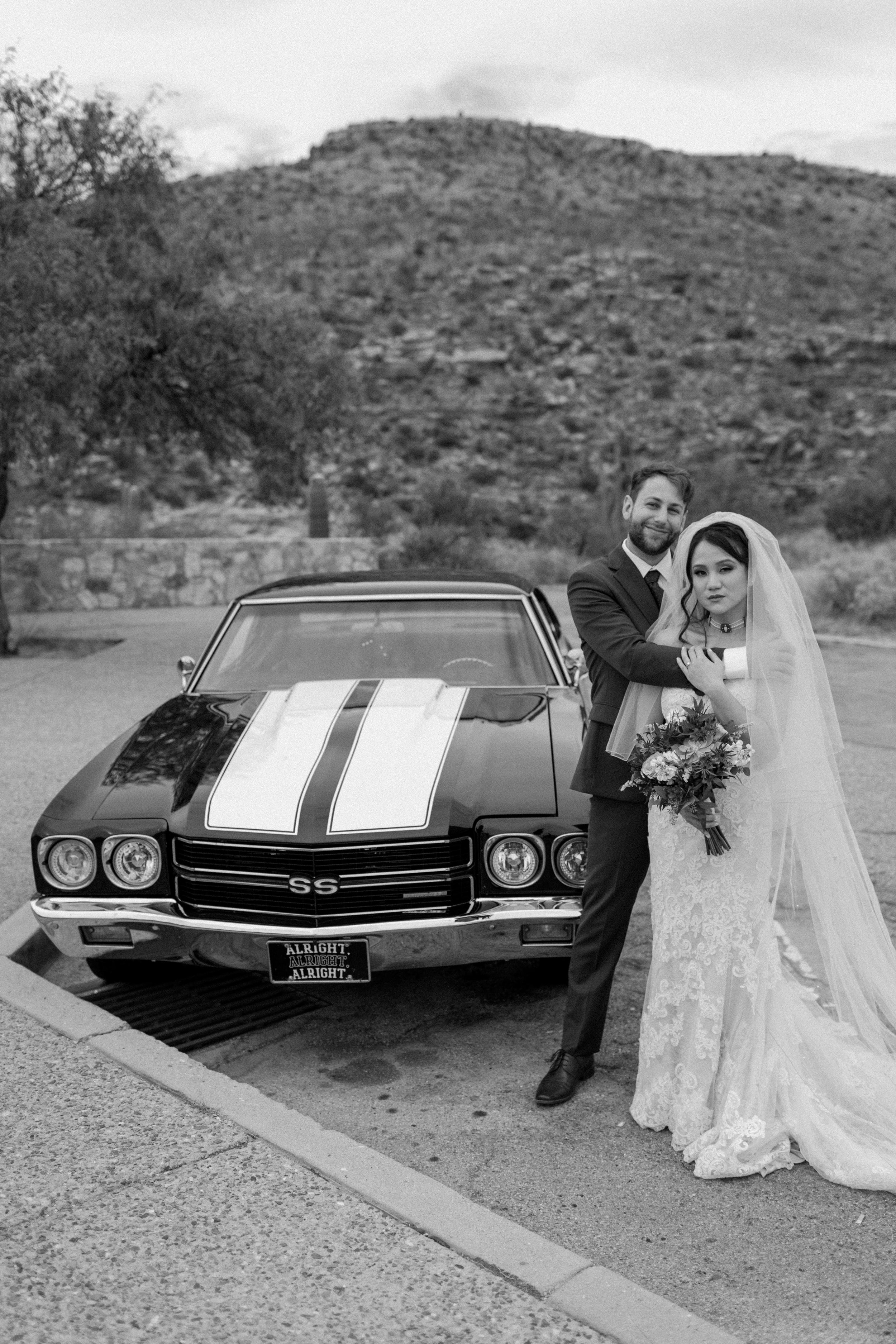  married couple standing next to vintage car after ceremony of rock climbing session 