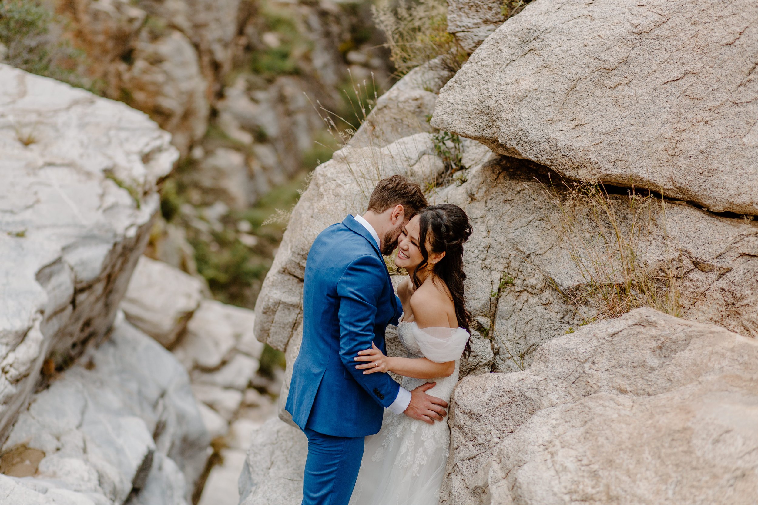  man leaning up against wife on the rocks by Arizona elopement photographer  