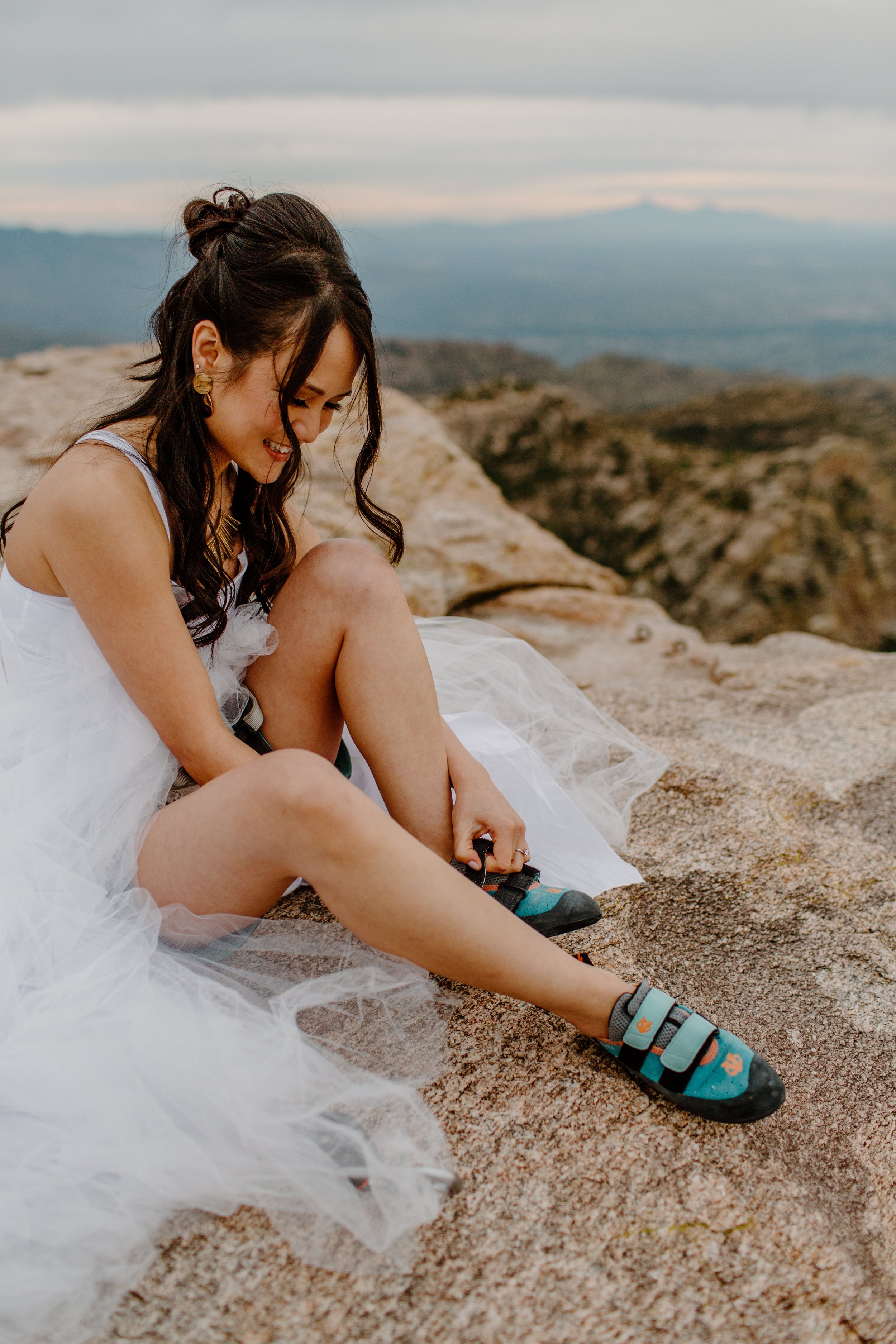  bride putting on climbing shoes after ceremony by Arizona elopement photographer  