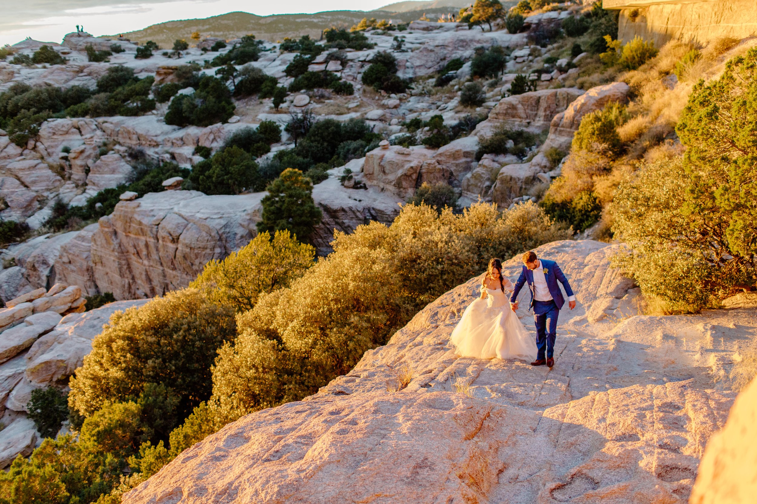  married couple walking on the rocks at golden hour sunset for rock climbing session 