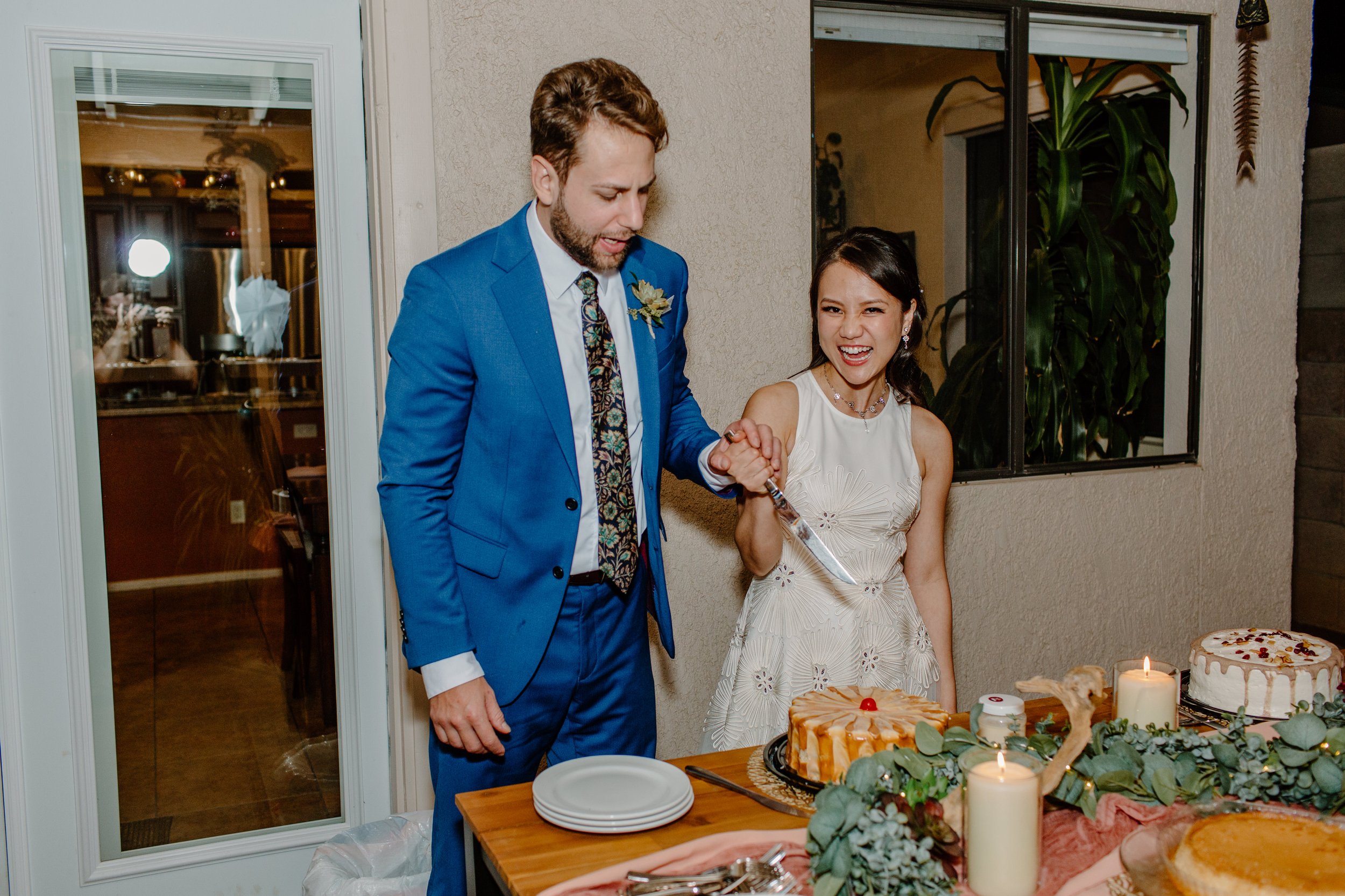  newly married couple cut wedding cake at reception by Arizona elopement photographer 