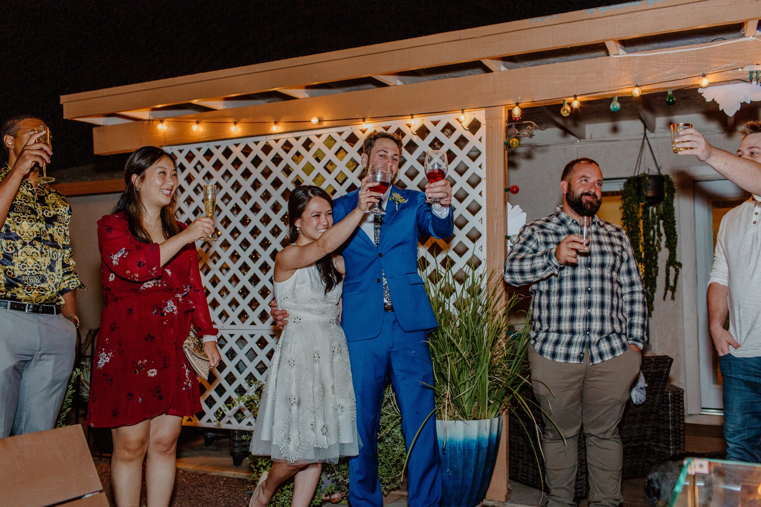  bride and groom with guests toast Champagne glasses at reception by Arizona elopement photographer 