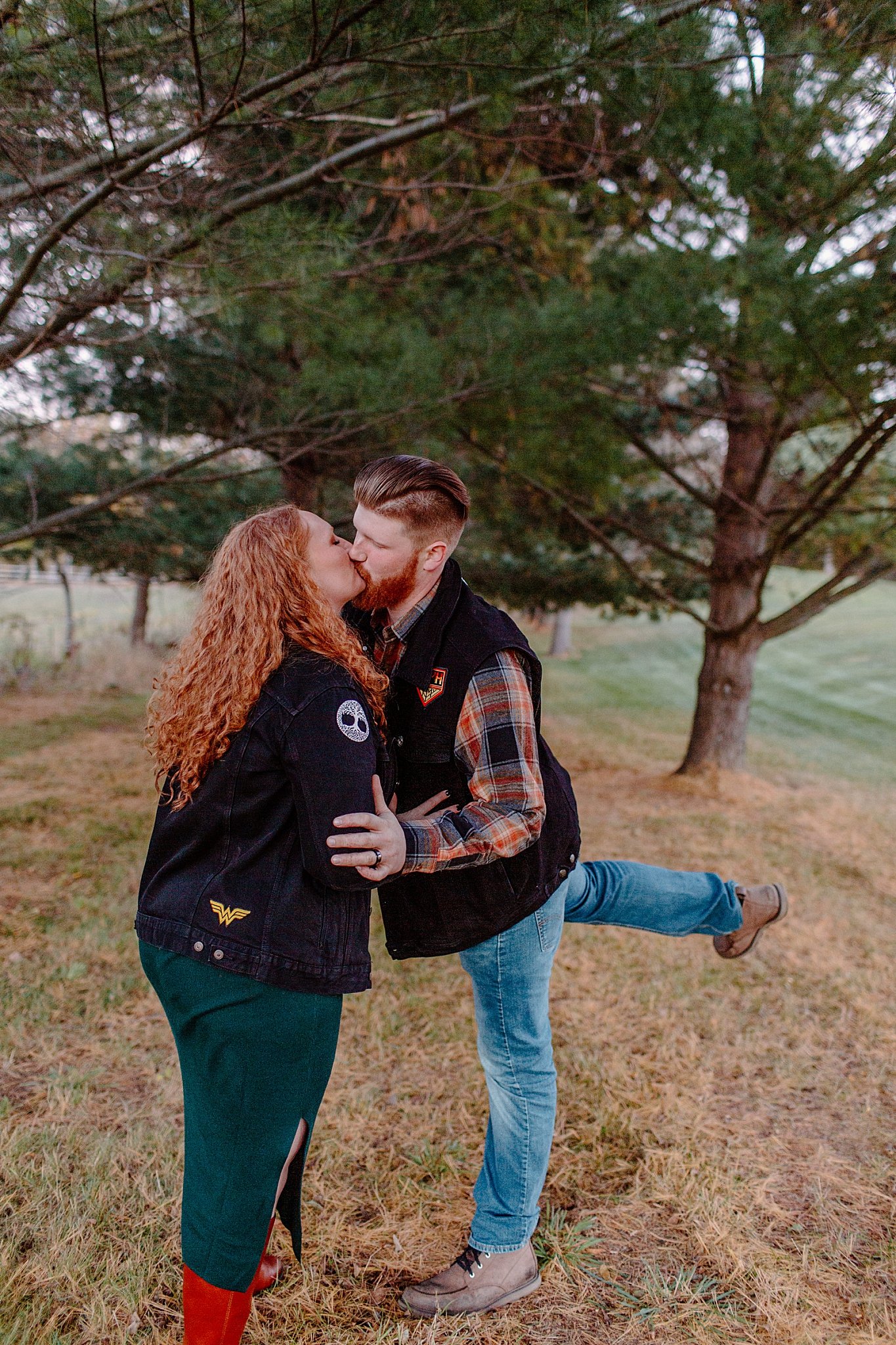 Man kisses woman with his leg in the air for Halloween engagement session 