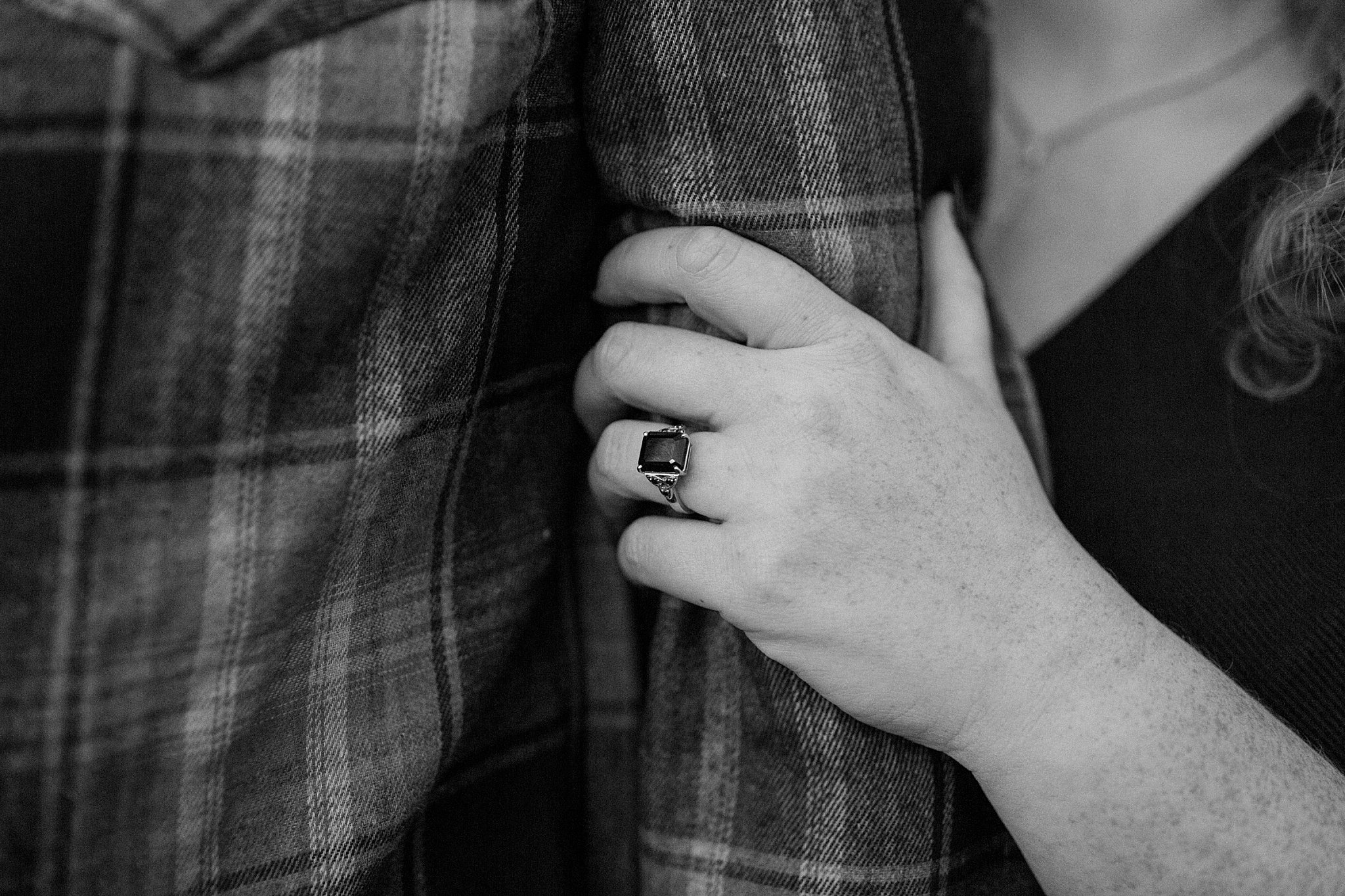  Hand shows off ring as it holds arm at Halloween engagement session 