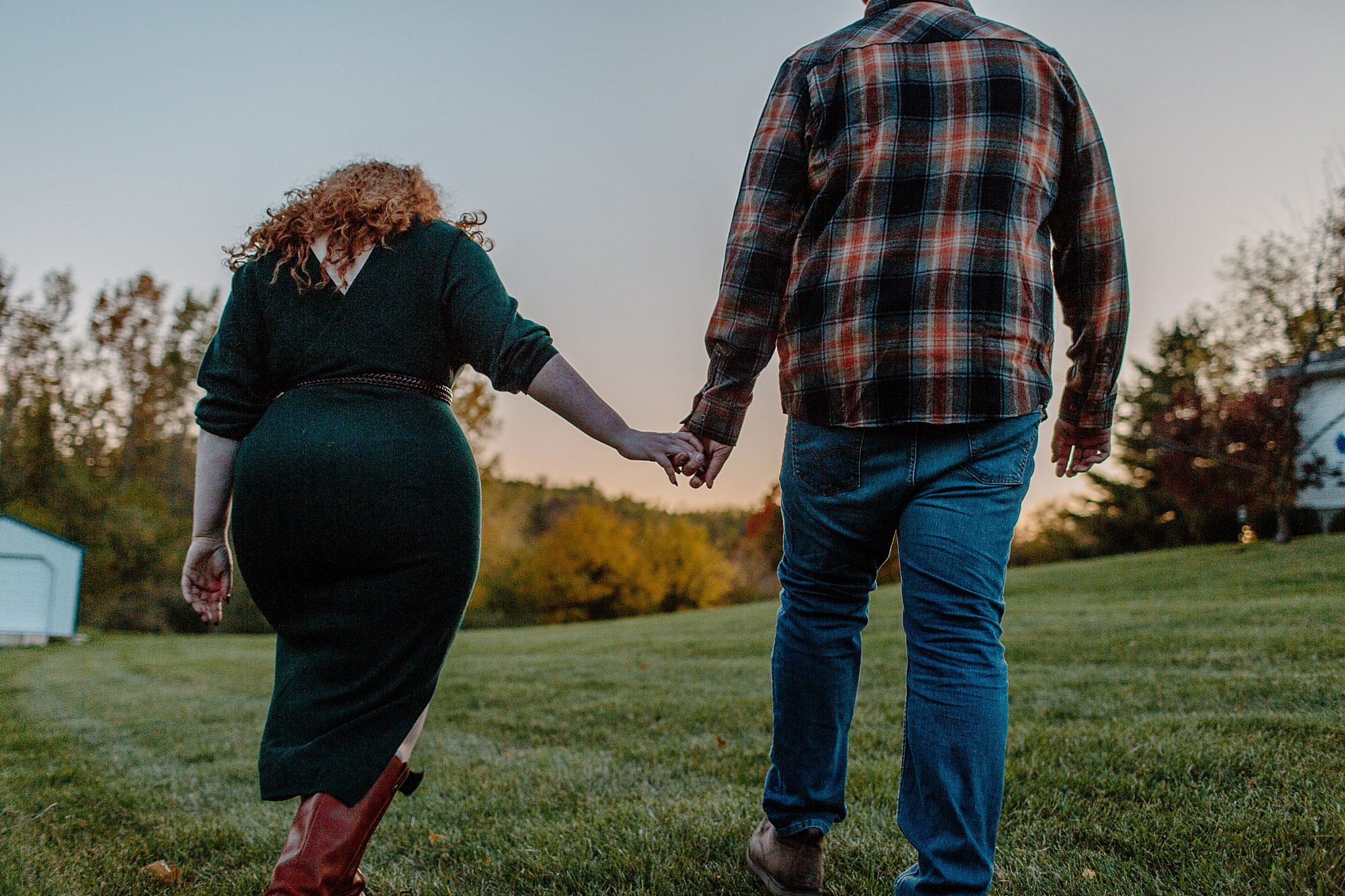  Man and woman hold hands and walk away at Halloween engagement session 